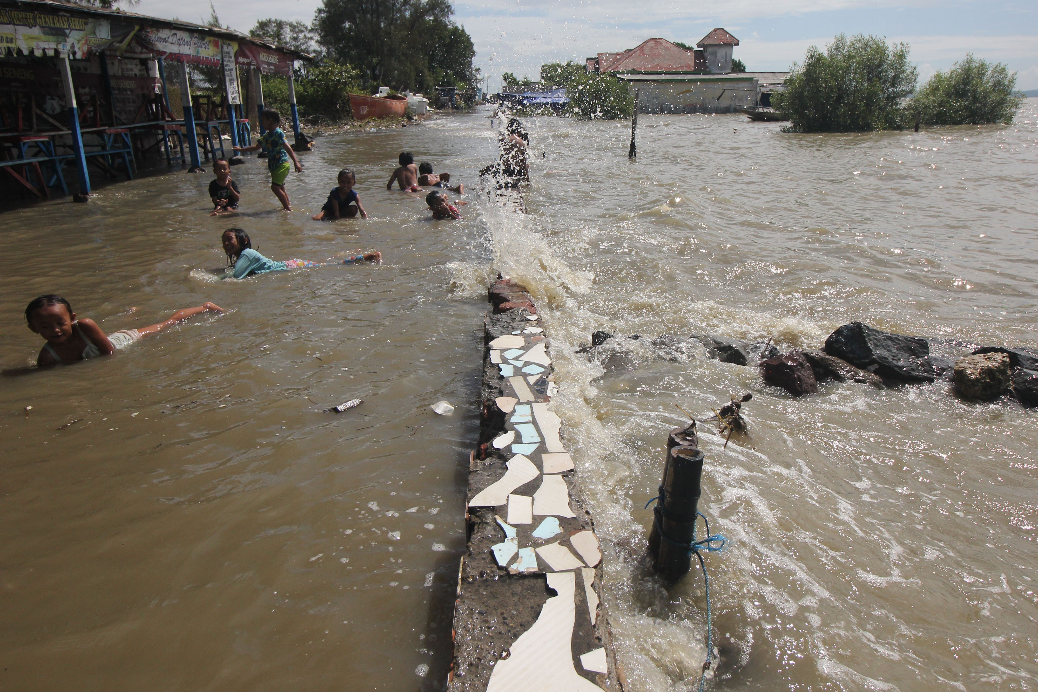Sejumlah anak bermain genangan rob di Kenjeran Park, Surabaya, Jawa Timur, Jumat (28/5).