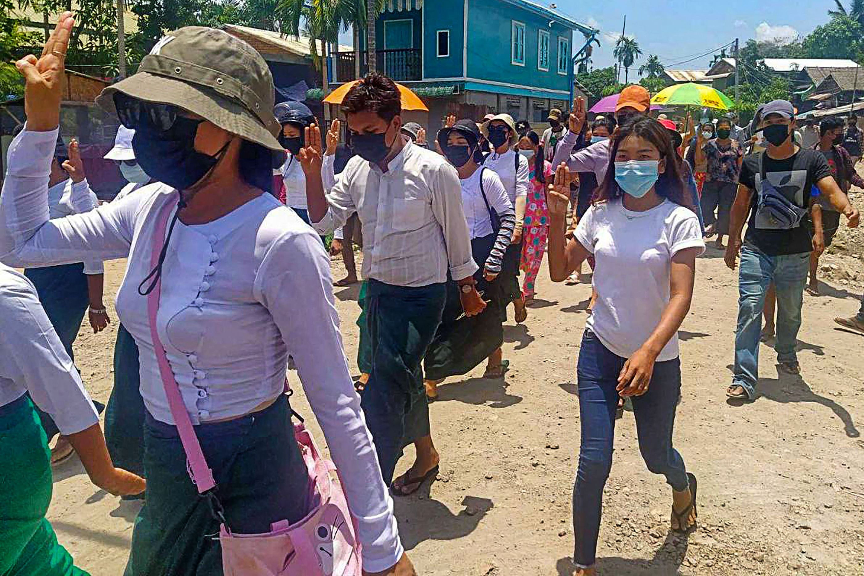Para demonstran menunjukkan 'tiga jari' sebagai tanda menentang kudeta militer saat unjuk rasa di Kota Dawei, Myanmar, Minggu (16/5). 