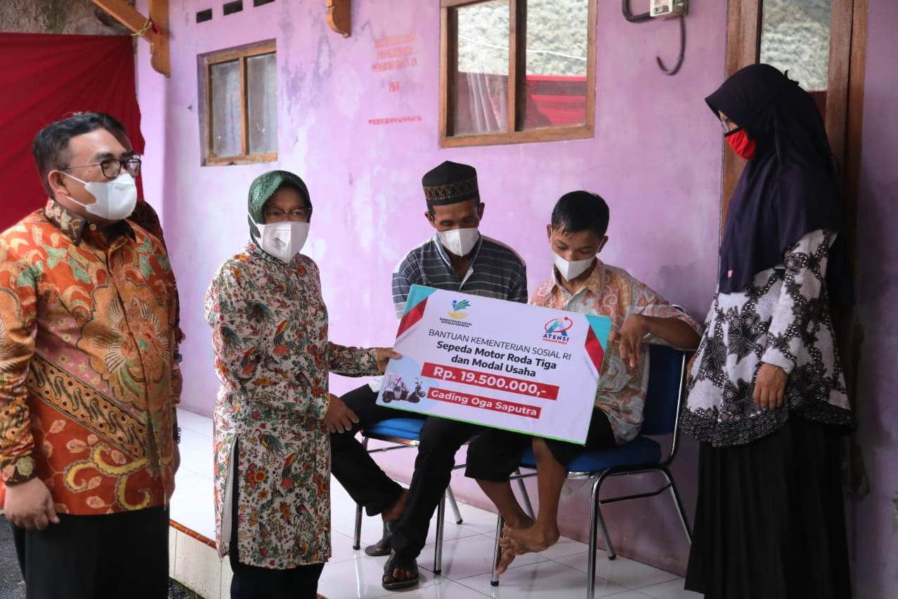Mensos Tri Rismaharini (kedua dari kiri) menyerahkan bantuan sepeda motor roda tiga kepada Gading. 