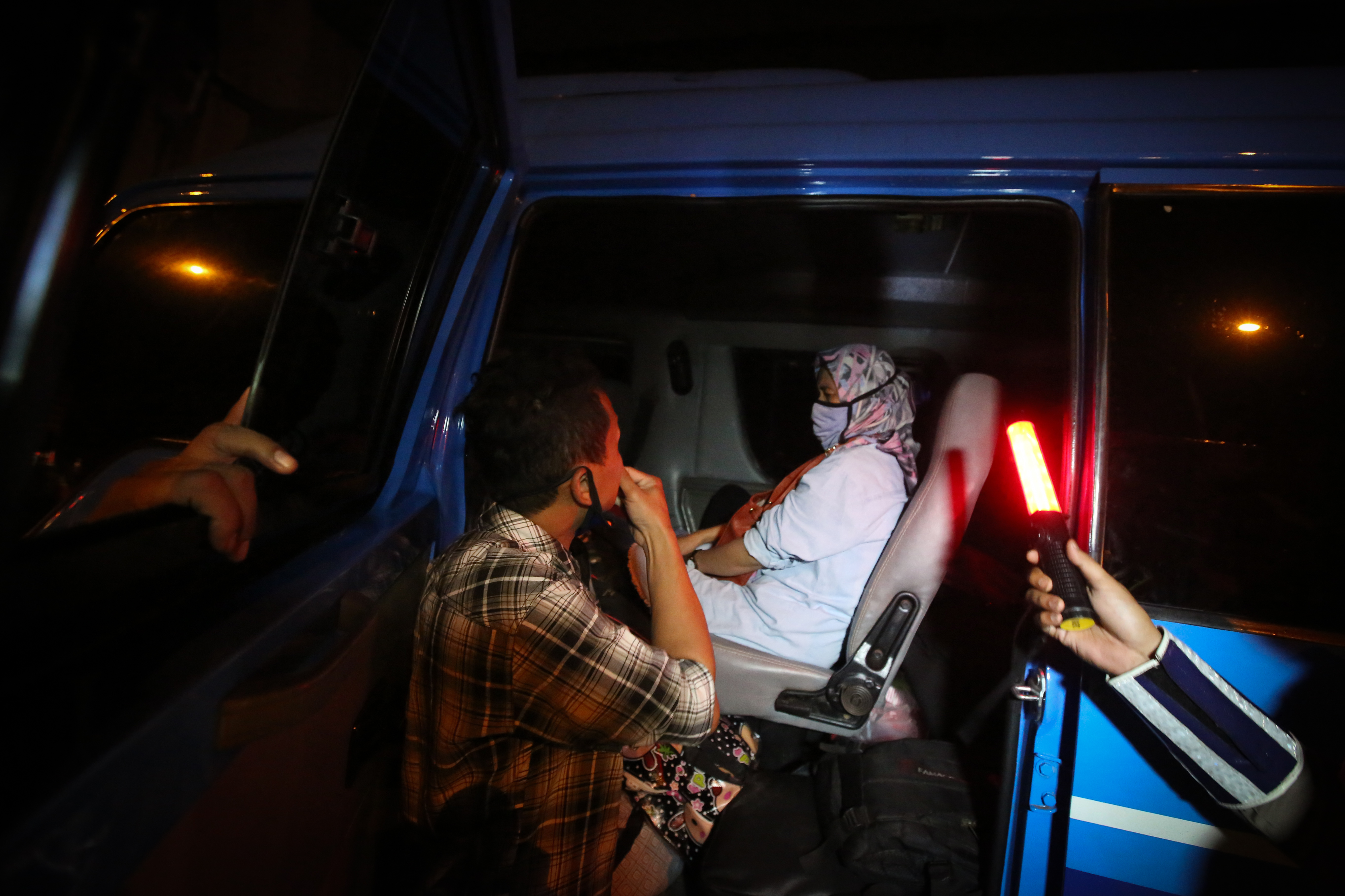 Petugas gabungan memeriksa penumpang kendaraan pribadi dan travel yang hendak meninggalkan Jakarta saat melewati pos penyekatan