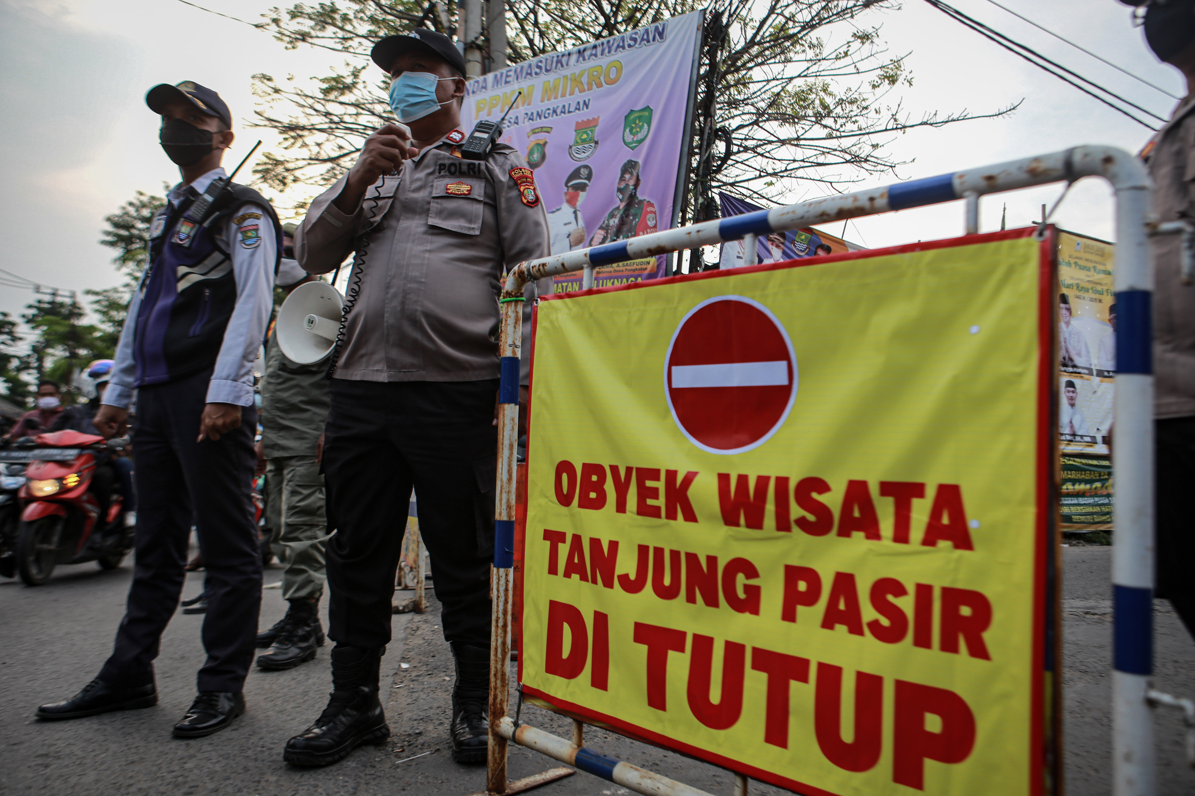 Petugas gabungan berjaga di pintu masuk area Pantai Tanjung Pasir, Kabupaten Tangerang, Banten, Minggu (16/5).