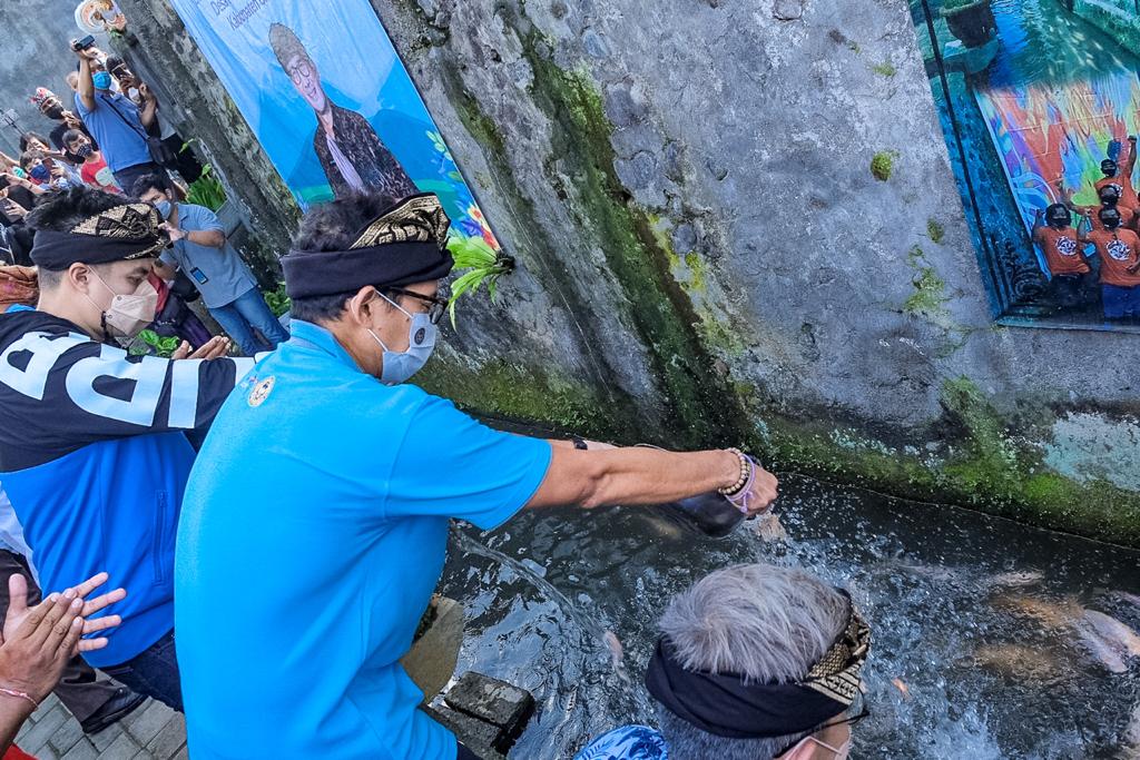 Menparekraf Sandiaga Uno menebar benih ikan di Desa Adat Mas, Ubud, Bali, Rabu (26/5)