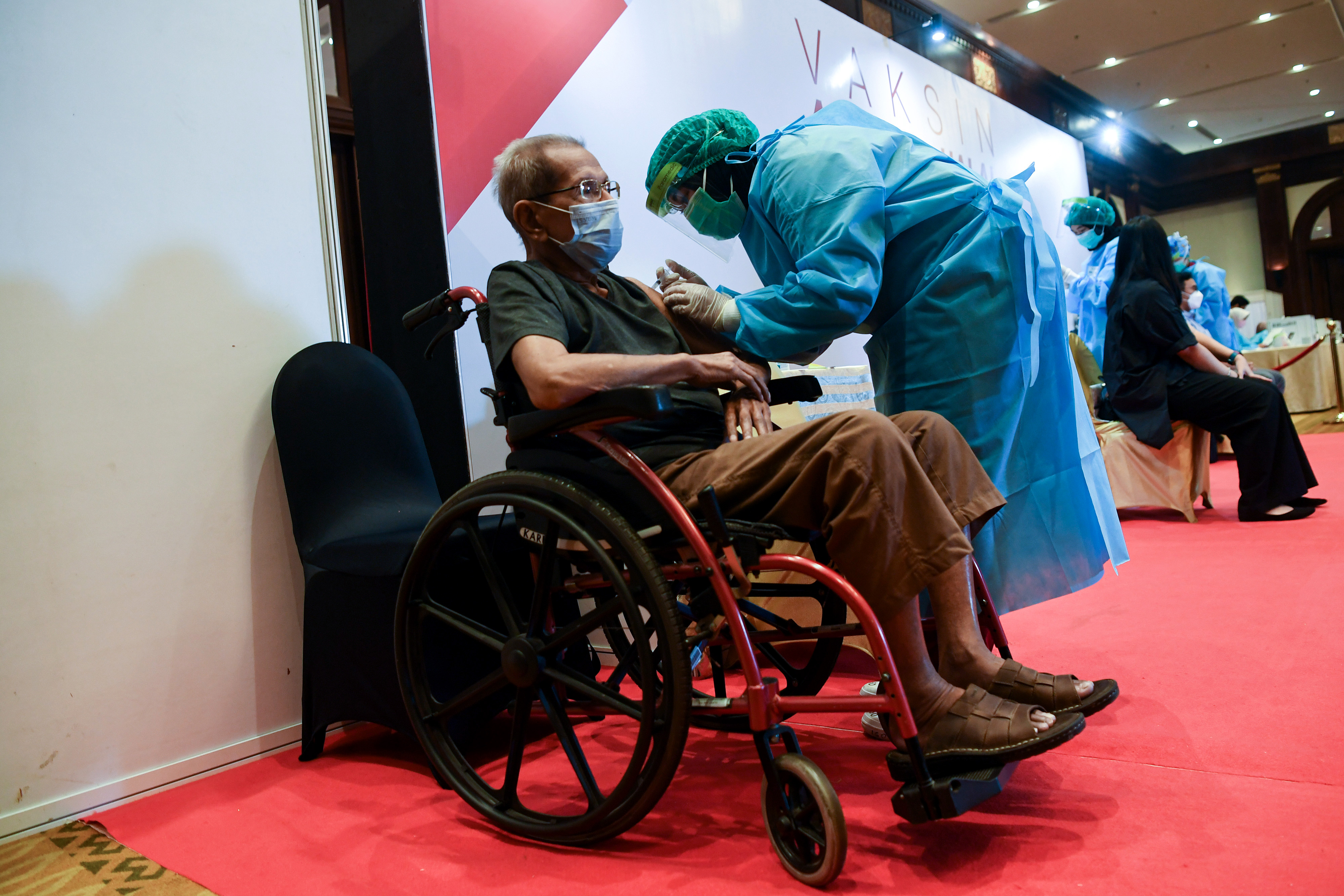 Ilustrasi petugas medis menyuntikkan vaksin covid-19 kepada lansia.