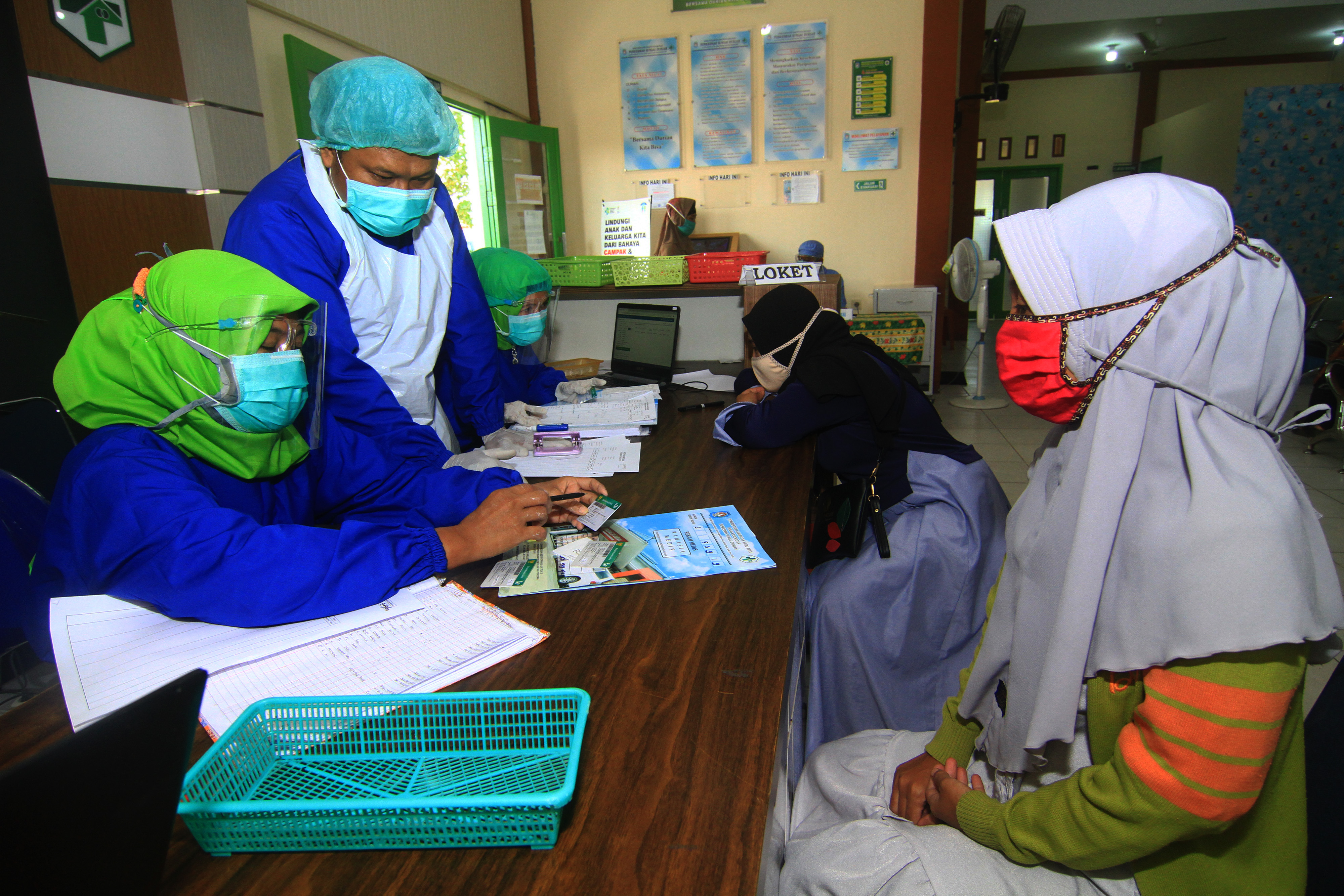 Petugas melayani pendaftaran pasien pengguna KIS di Puskesmas Sungai Durian, Kabupaten Kubu Raya, Kalimantan Barat, Jumat (28/8/2020)