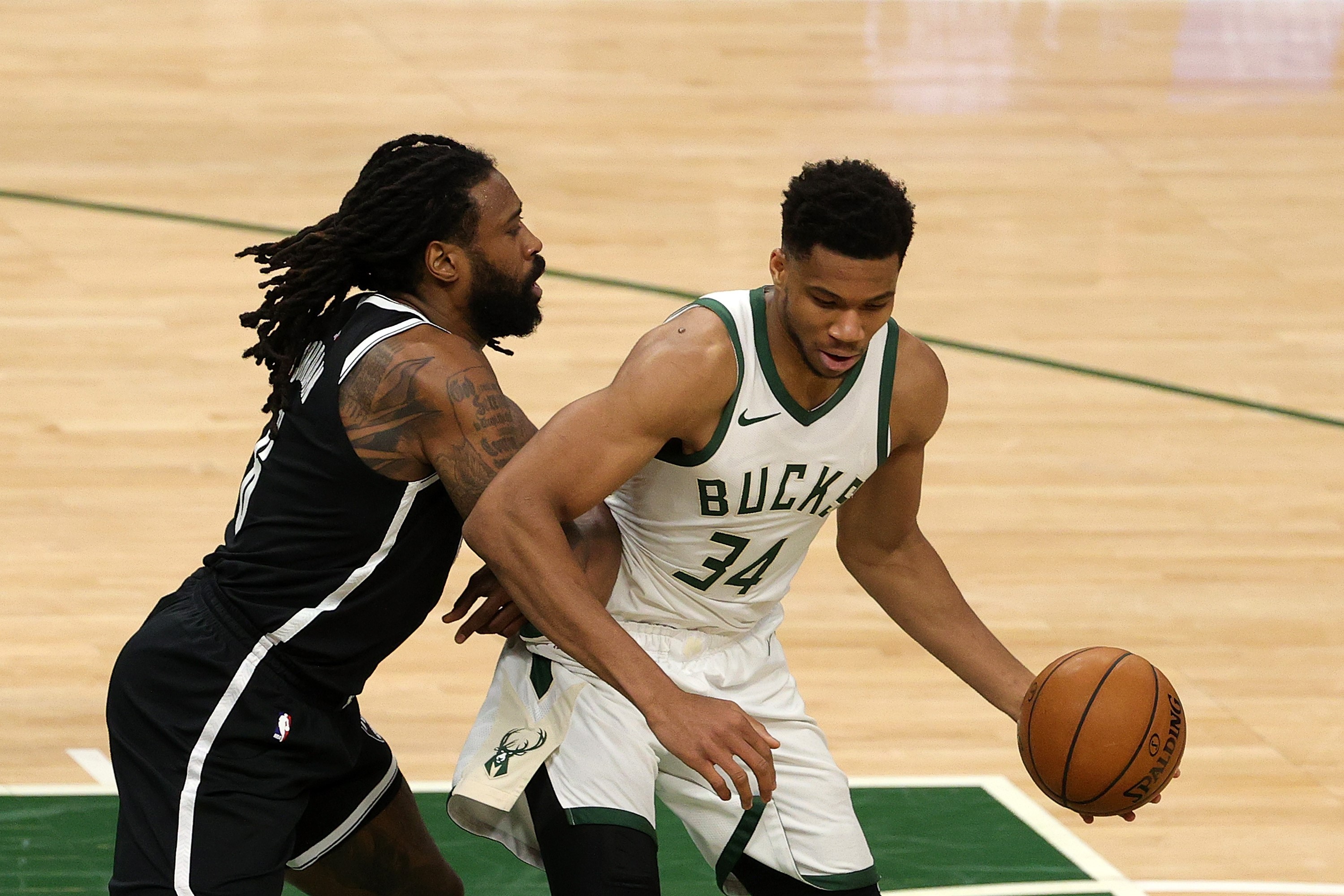 Pebasket Giannis Antetokounmpo (kanan) dari Milwaukee Bucks mencoba bertahan dari gangguan pemain Brooklyn Nets, DeAndre Jordan.