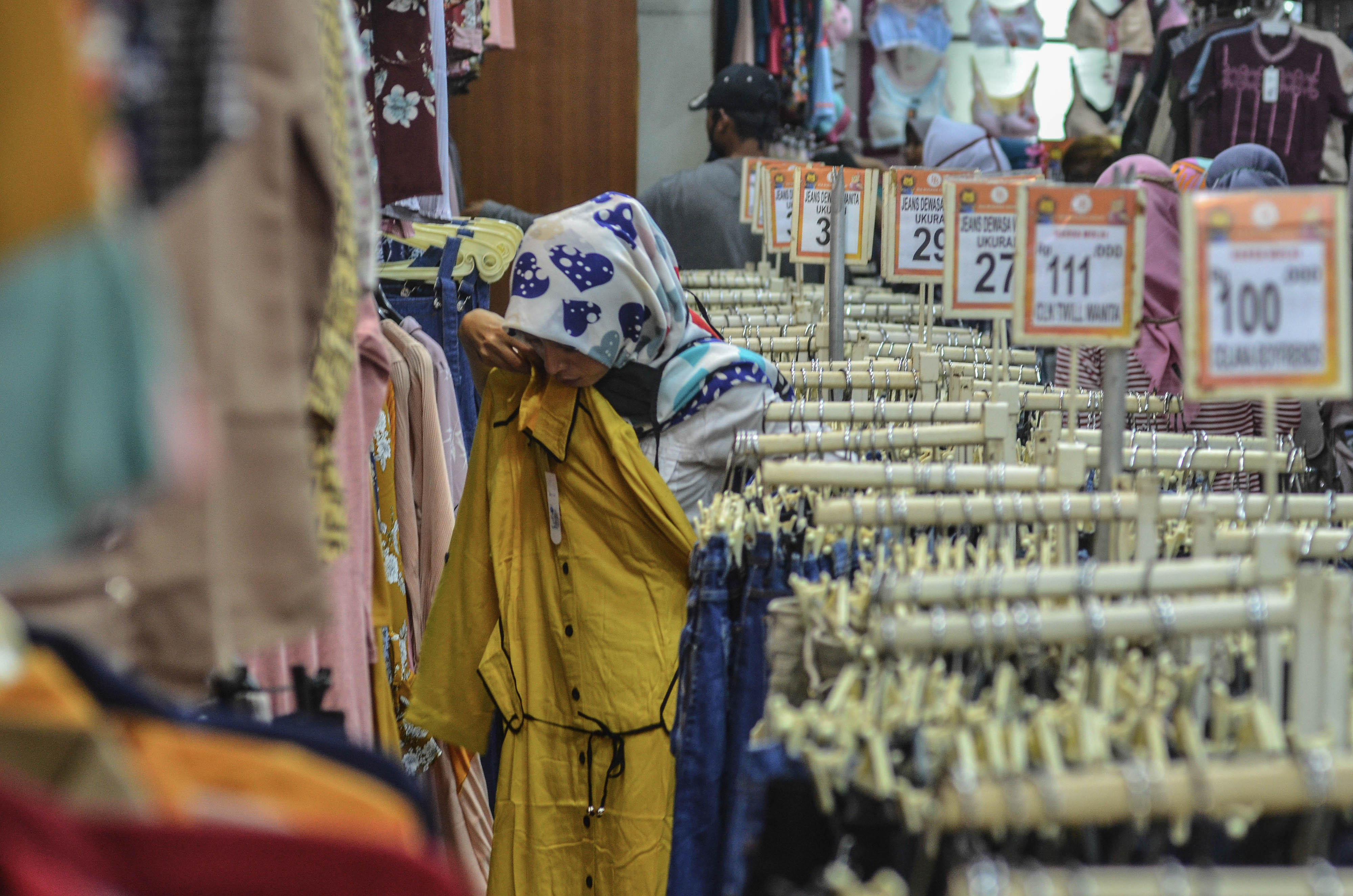 Ilustrasi pembeli saat memilih baju Lebaran di pusat penjualan pakaian.