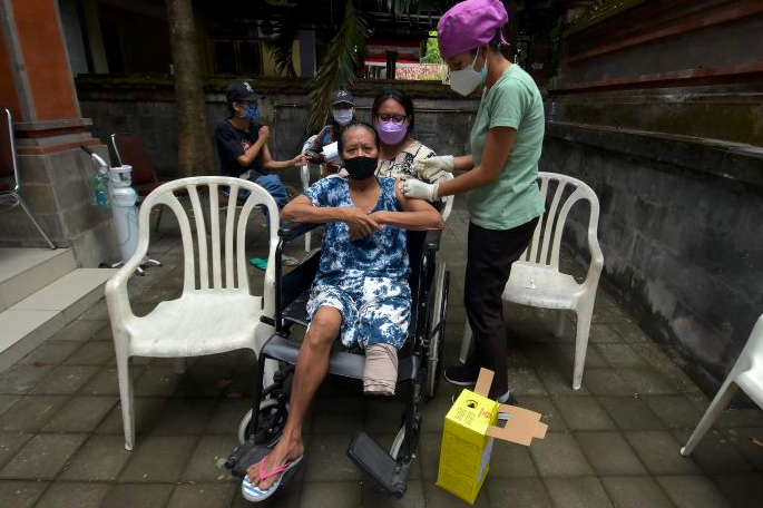 Ilustrasi - Petugas kesehatan menyuntikkan vaksin COVID-19 kepada penyandang tuna daksa di Rumah Bisabillitas, Denpasar, Bali.