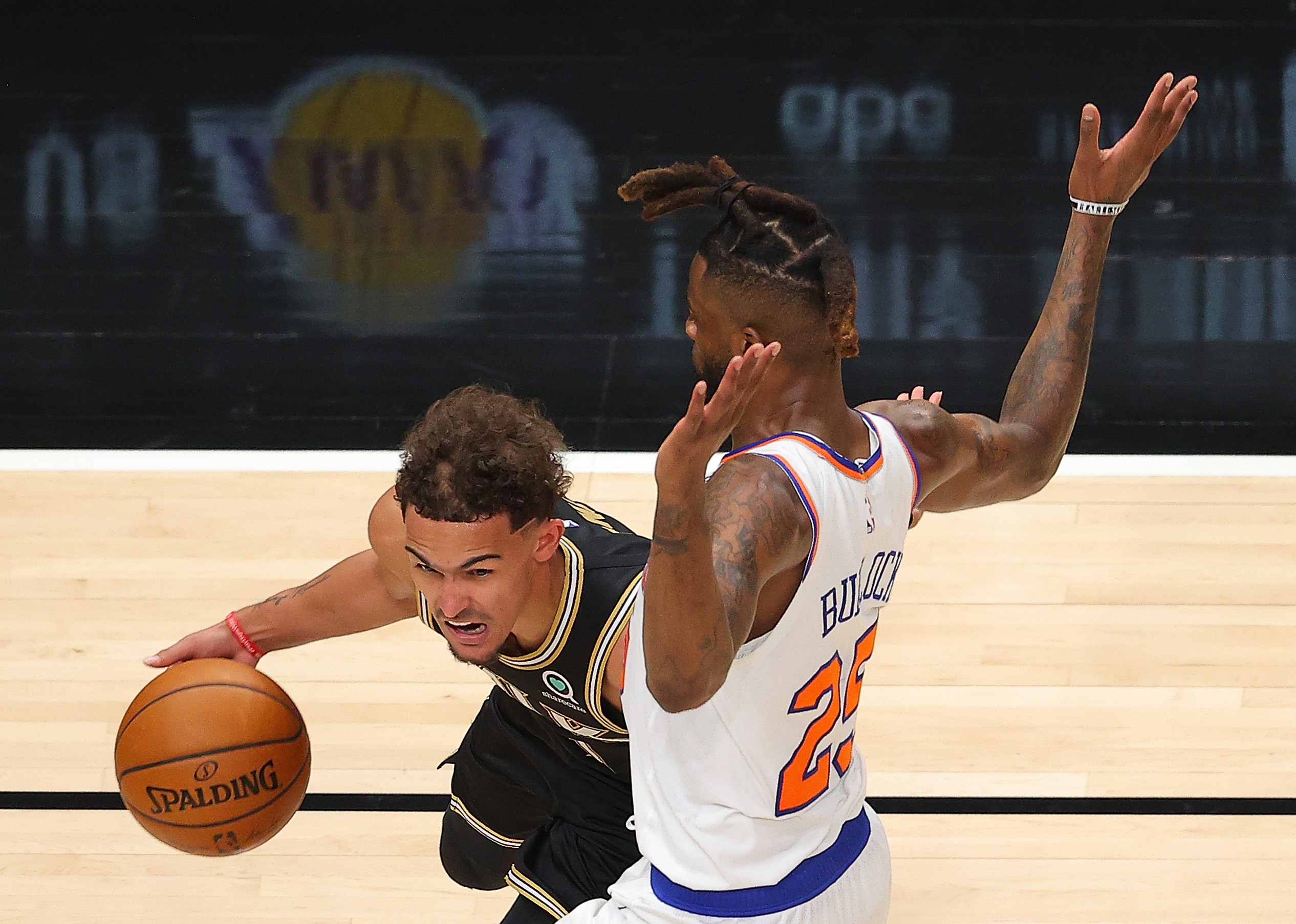 Pemain Hawks Trae Young berusaha melewati hadangan pemain Knicks Reggie Bullock dalam laga playoff NBA.