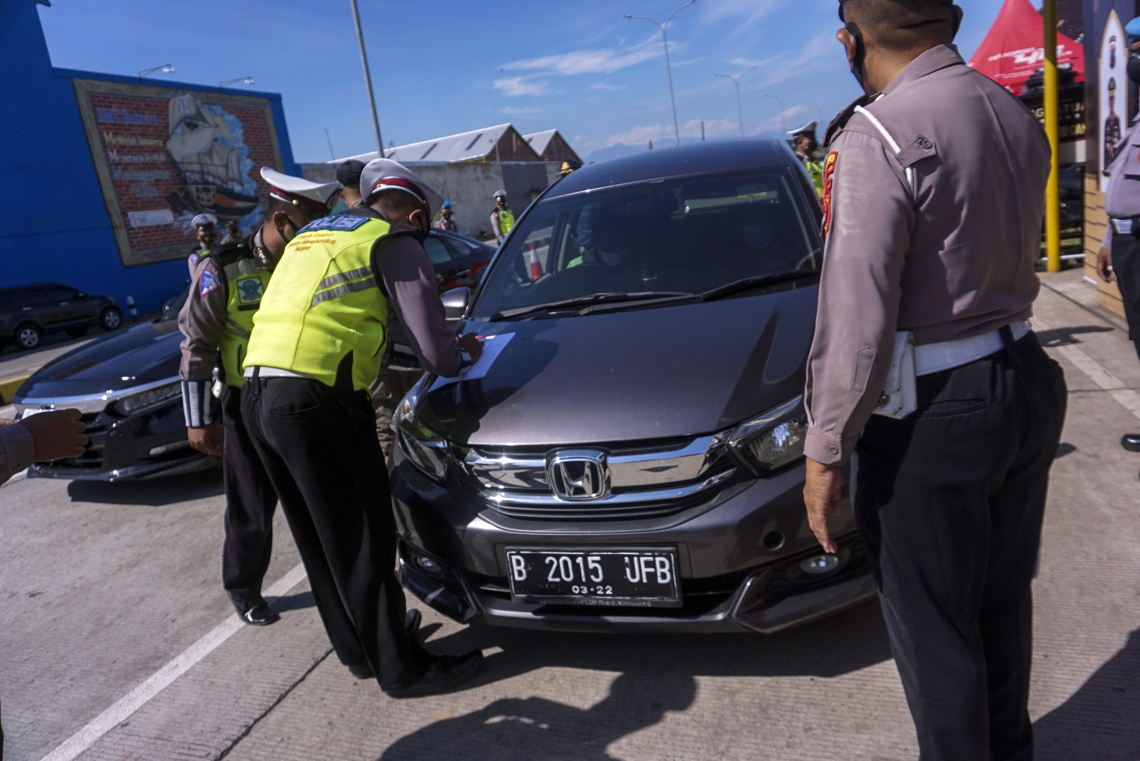  Petugas kepolisian memeriksa kelengkapan surat perjalanan pengendara di Exit Tol Setono, Pekalongan, Jawa Tengah, Senin (3/5/2021). 