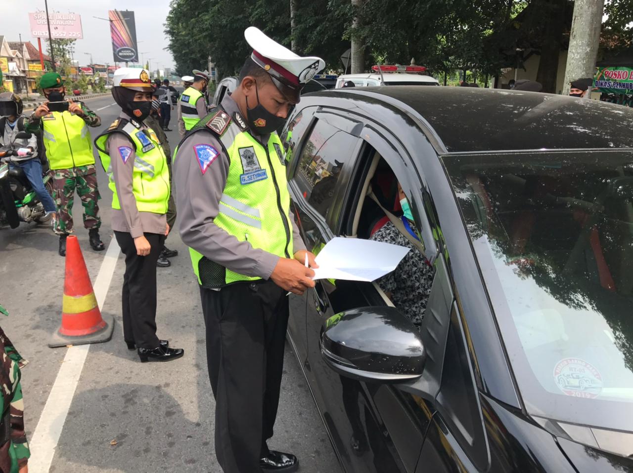 Petugas memeriksa kendaraan berpelat luar daerah yang akan masuk Kabupaten Klaten di pos perbatasan Jateng-DI Yogyakarta di Prambanan.