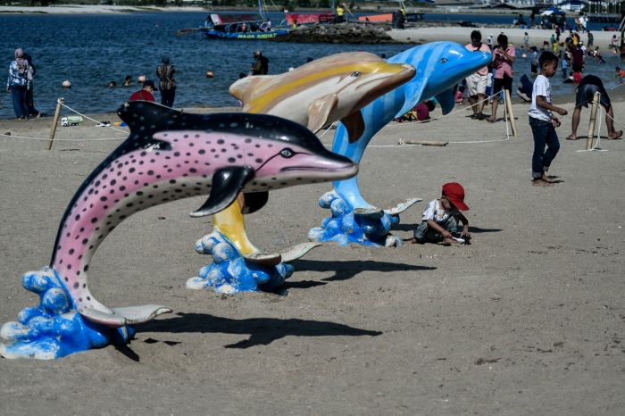 Sejumlah pengunjung bermain di Pantai Lagoon, Taman Impian Jaya Ancol, Jakarta, Minggu (27/12/2020).