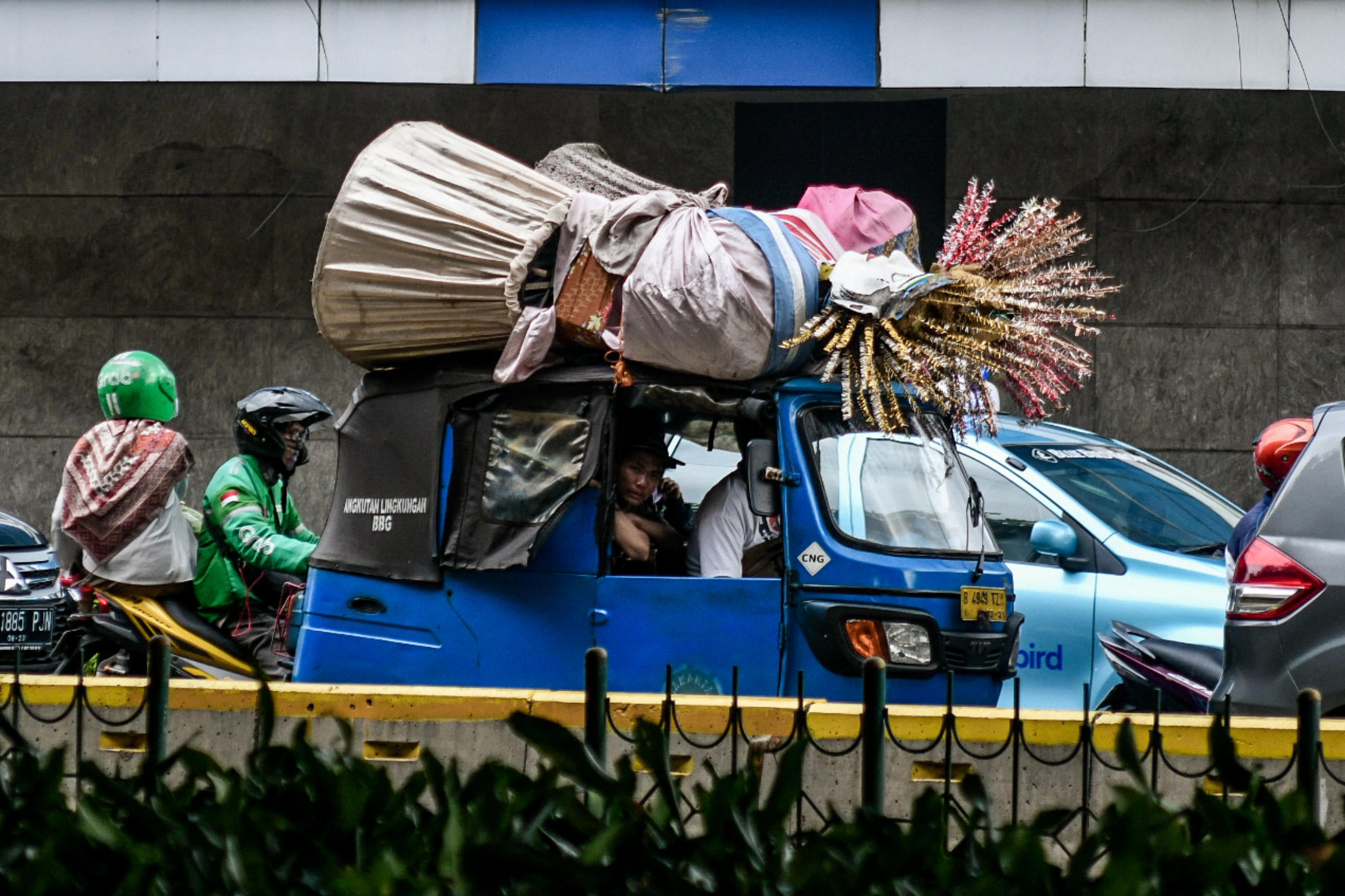 Warga mengangkut ondel-ondel menggunakan bajaj di kawasan Senen, Jakarta.