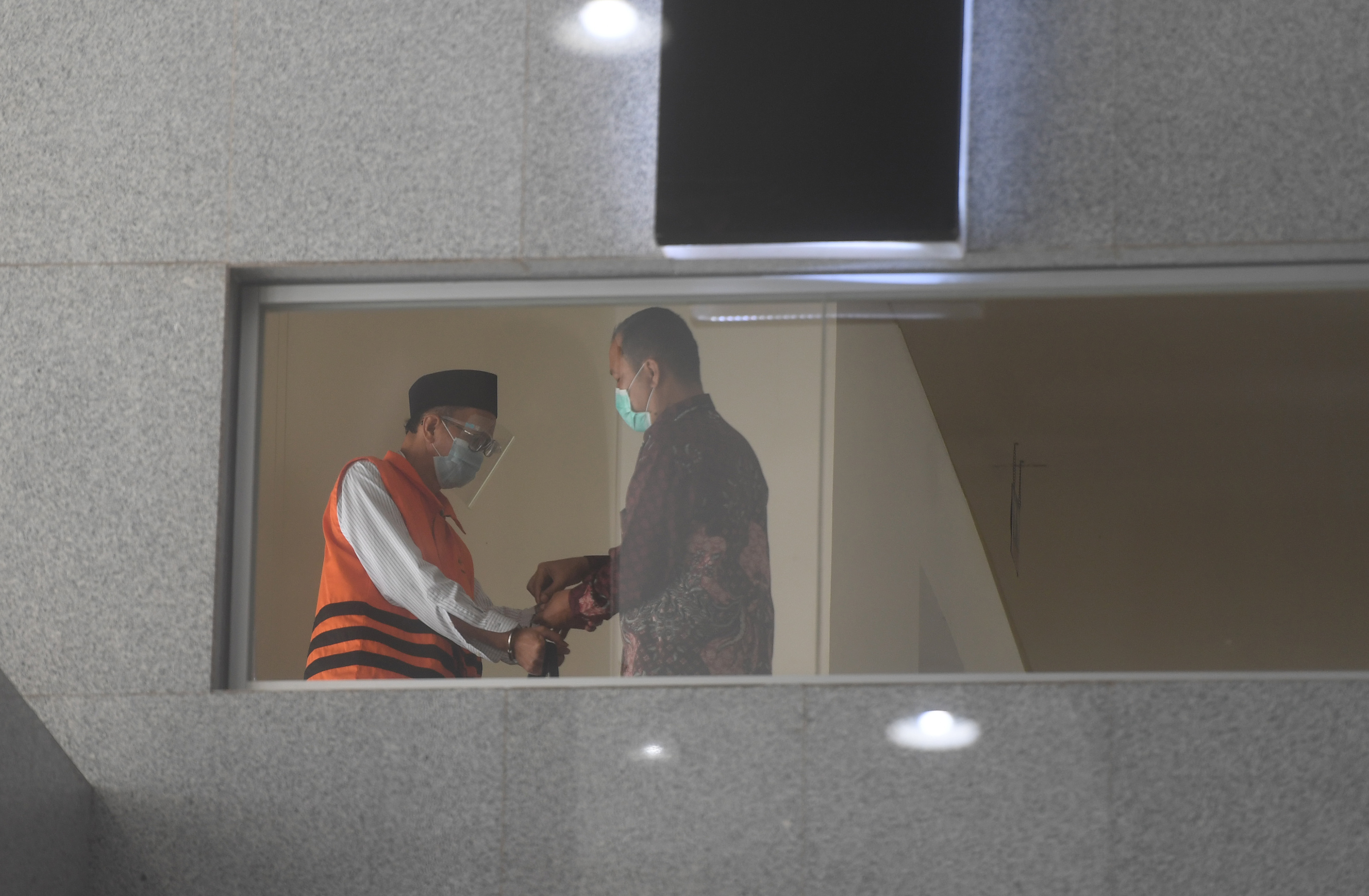 Petugas saat memasangkan borgol kepada tersangka mantan Kepala BIG Priyadi Kardono.