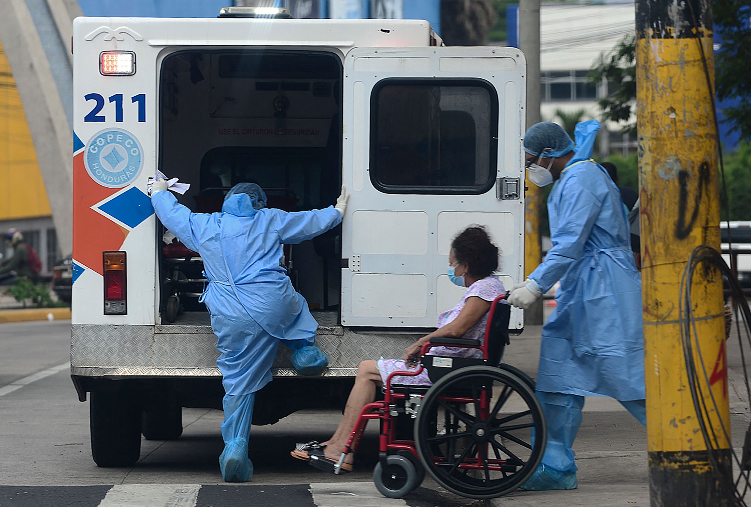 Tenaga kesehatan mengevakuasi pasien covid-19 dari rumahnya di Tegucigalpa, Honduras.