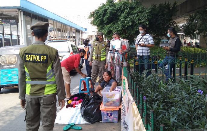 Petugas Satpol PP Jakarta Pusat menertibkan pedagang di trotoar seberang Stasiun Tanah Abang, Senin (10/5).