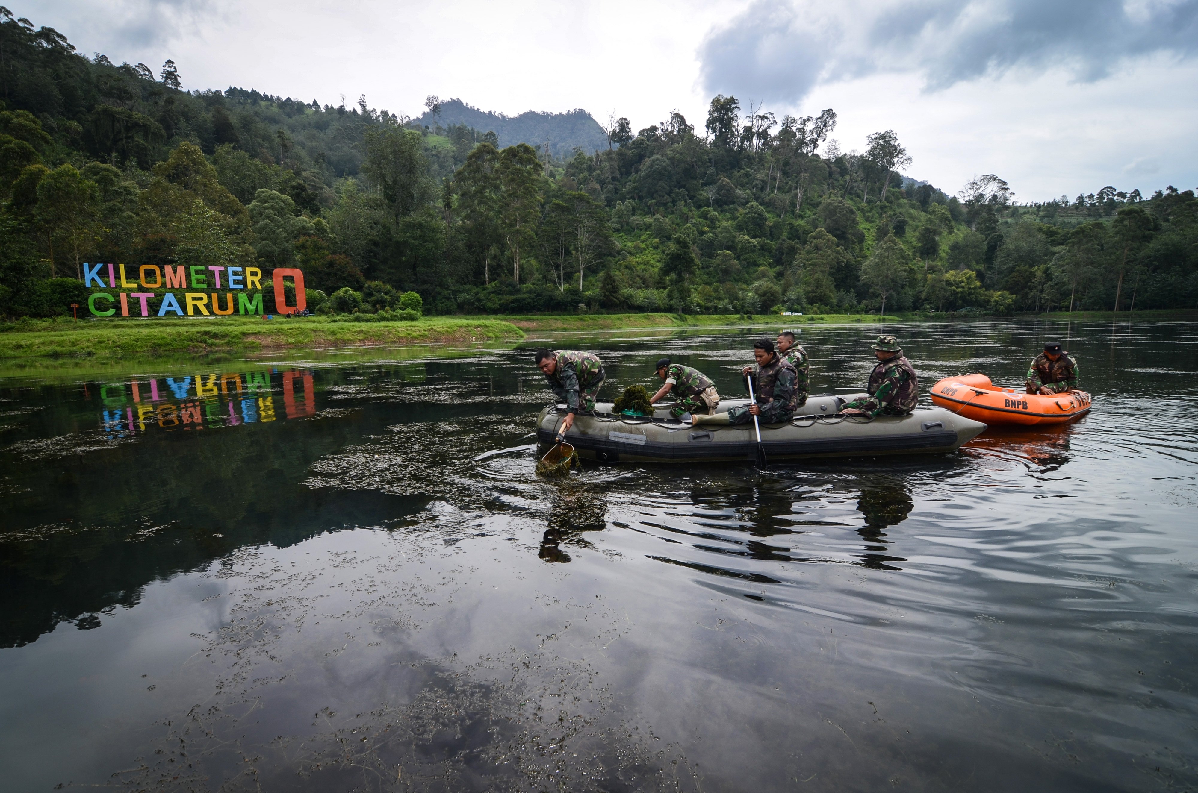 Anggota TNI mengambil sampah saat melakukan patroli bersih di Kawasan Hulu Sungai Citarum, Situ Cisanti, Kabupaten Bandung, Jawa Barat.