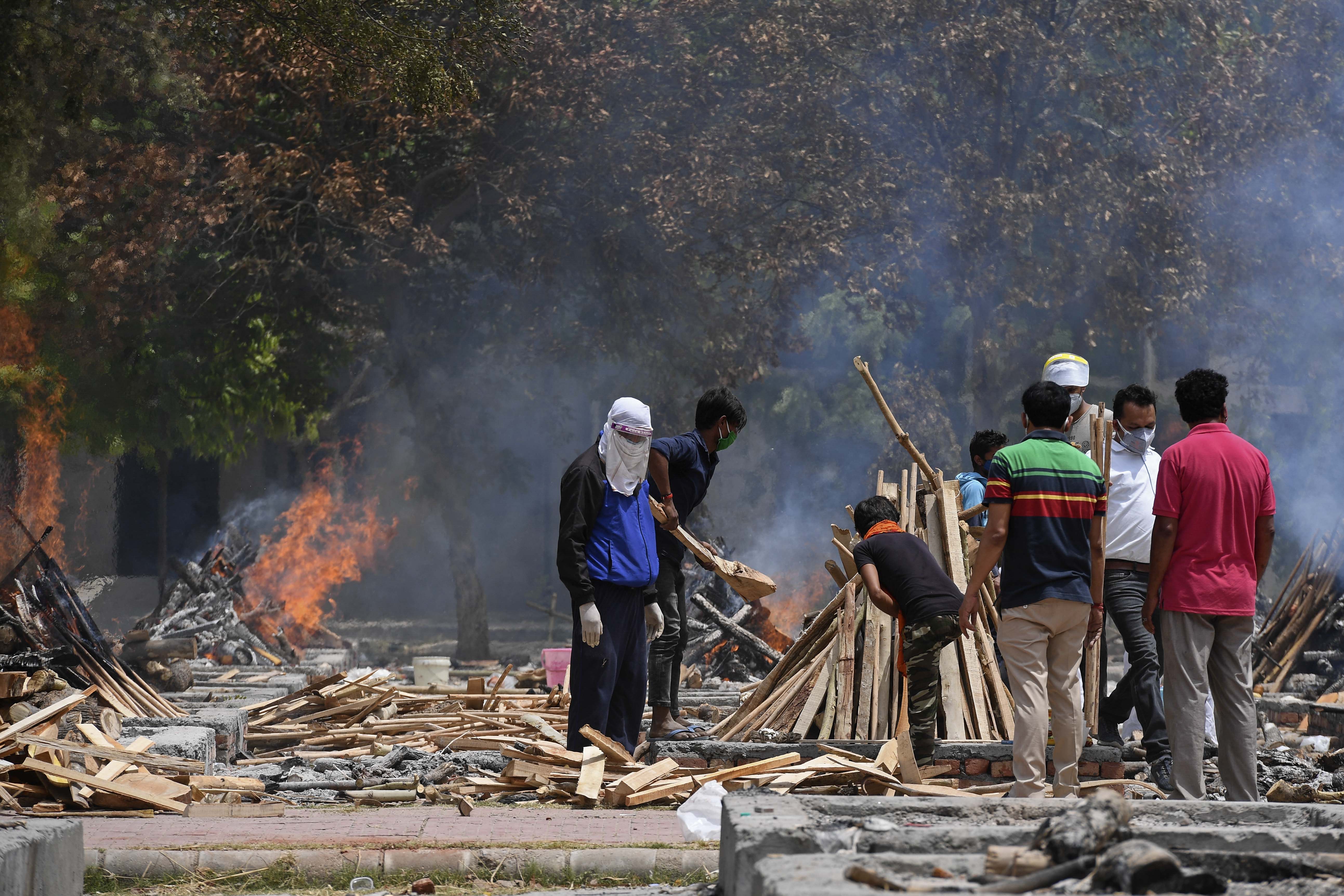Sanak saudara dari korban meninggal akibat Covid-19 di lokasi kremasi di New Delhi, India, Selasa (4/5).