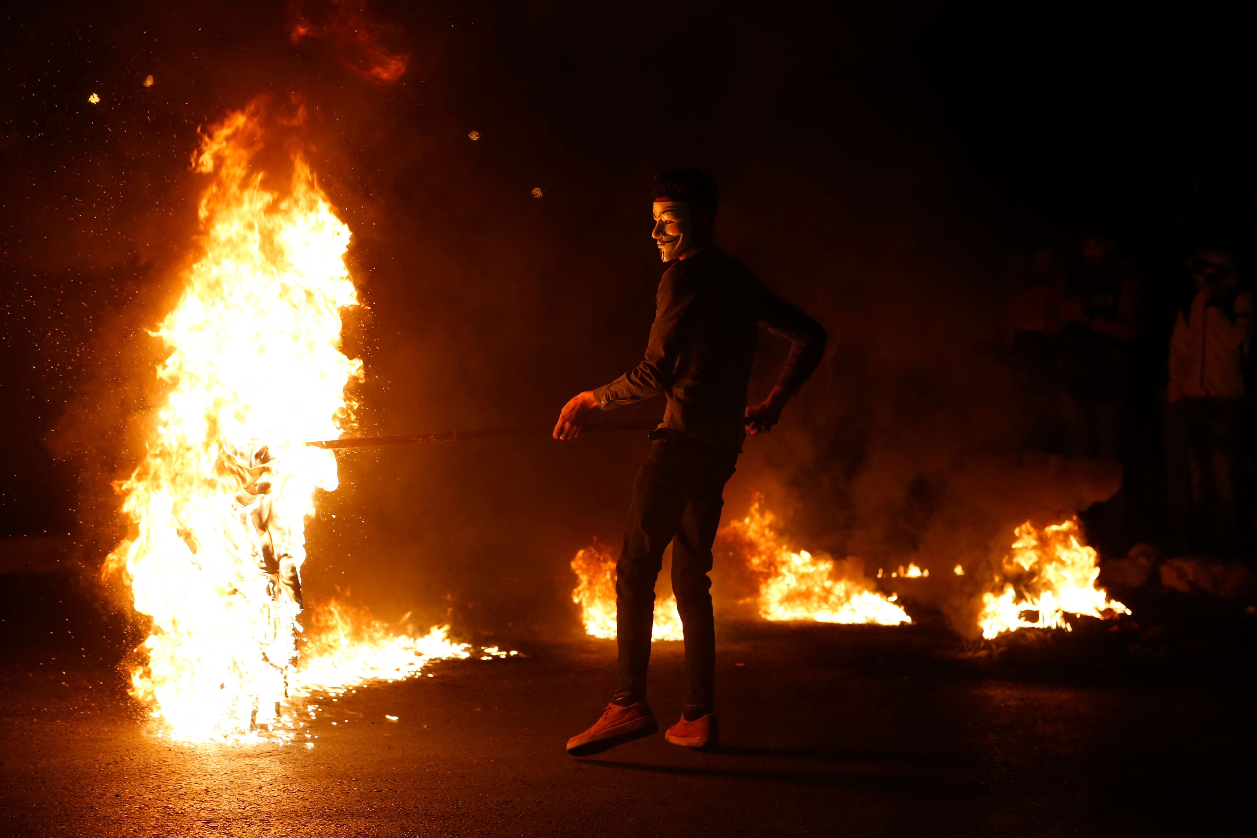 Demonstran Palestina, yang mengenakan topeng Guy Fawkes, melakukan aksi di Beit El, dekat Ramallah, Tepi Barat.