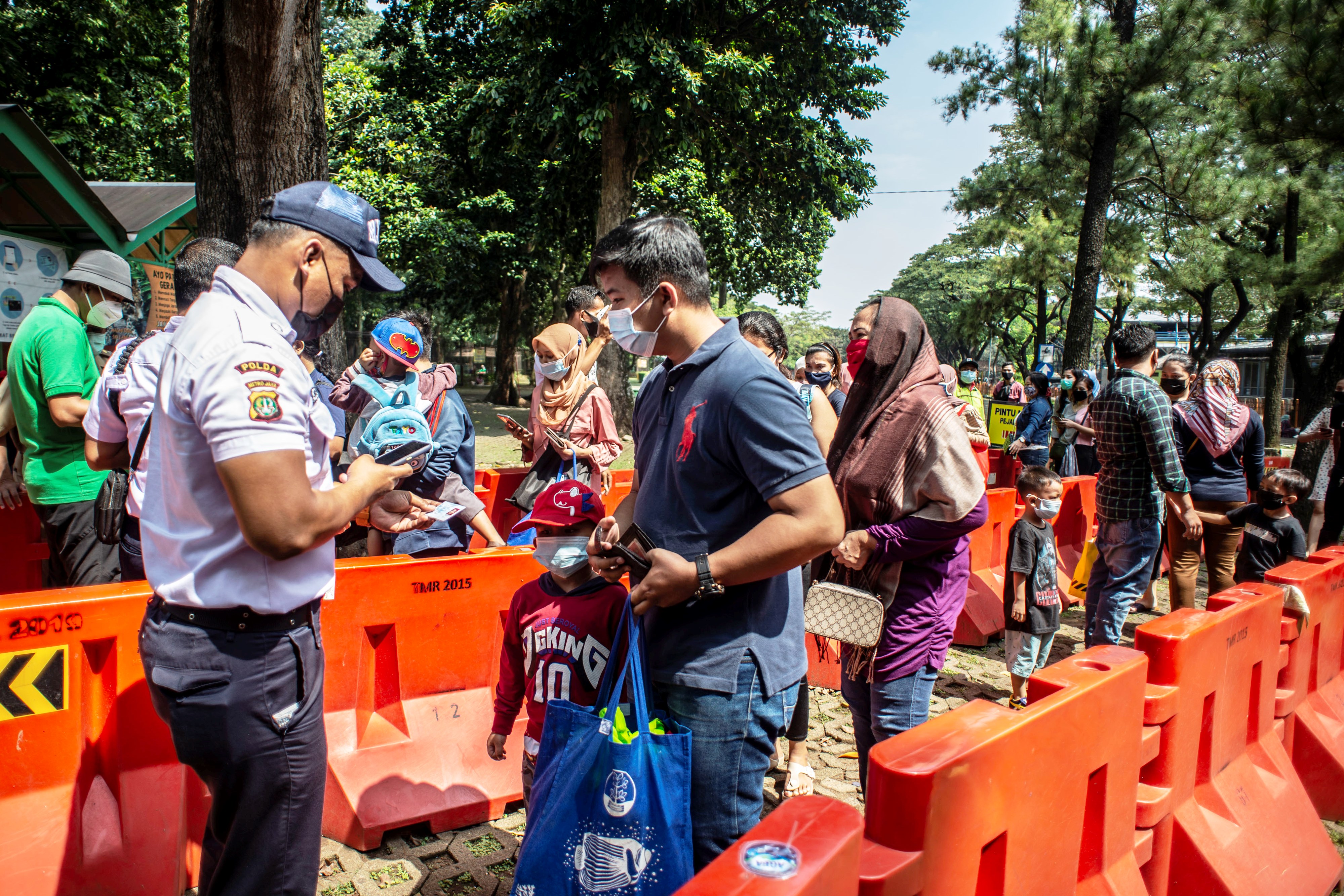 Petugas memeriksa identitas diri wisatawan sebelum memasuki kawasan Taman Margasatwa Ragunan di Jakarta, Kamis (14/5/2021)