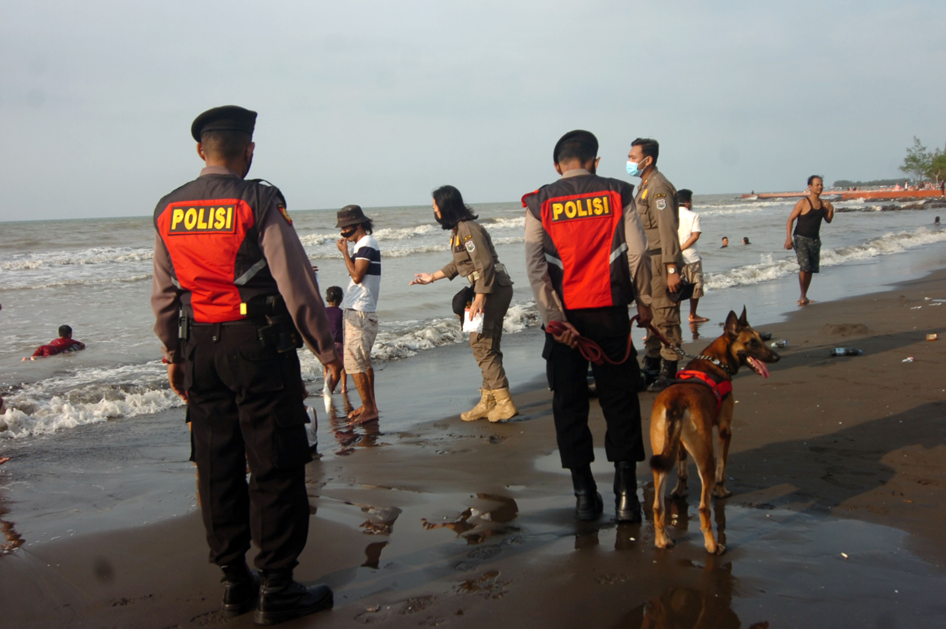 Sejumlah personel kepolisian dan Satpol PP memberikan arahan tentang prokes kepada pengunjung di obyek wisata PAI, Tegal.
