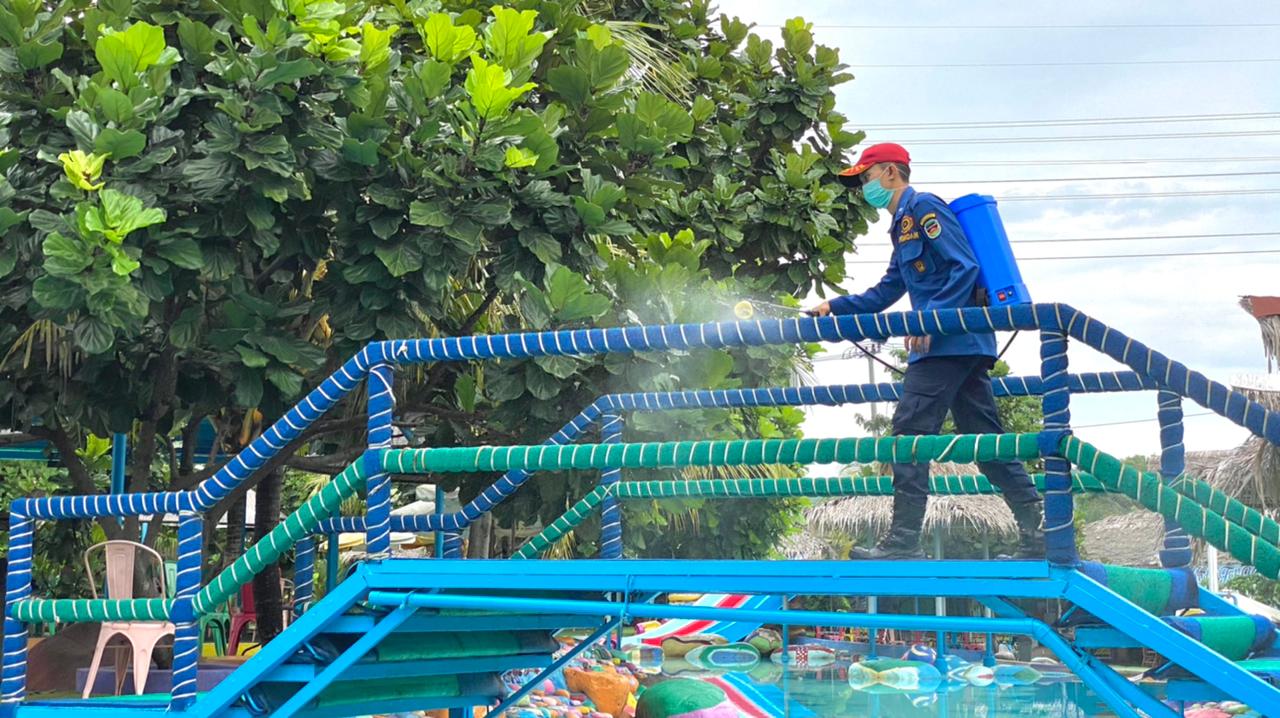 Petugas menyemprotkan disinfektan di lokasi wisata di Purwakarta, Jawa Barat.