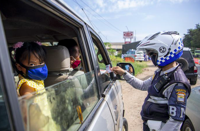 Petugas polisi memeriksa kelengkapan surat pengemudi kendaraan roda empat.