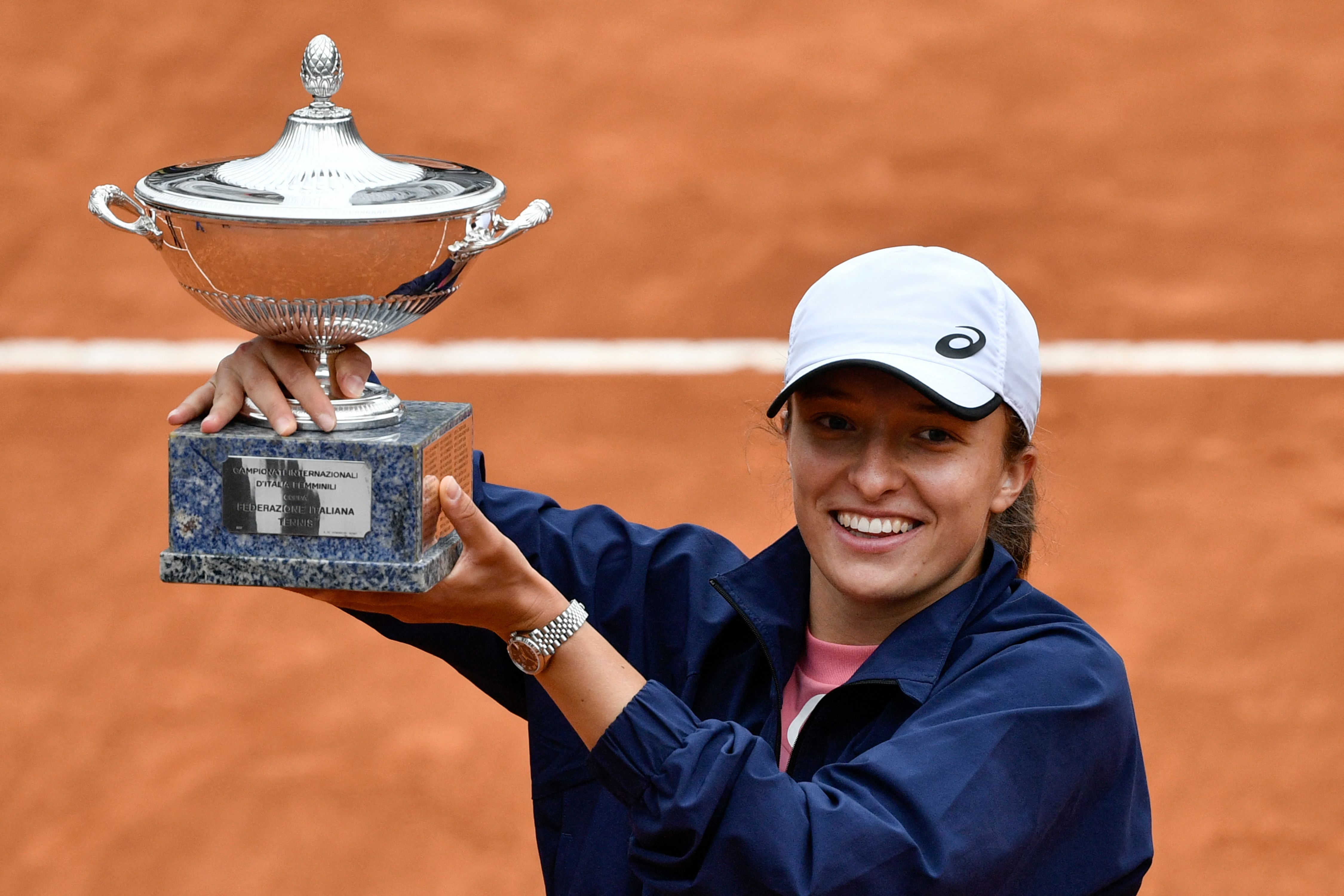 Petenis Polandia Iga Swiatek mengangkat trofi juara Italia Terbuka.