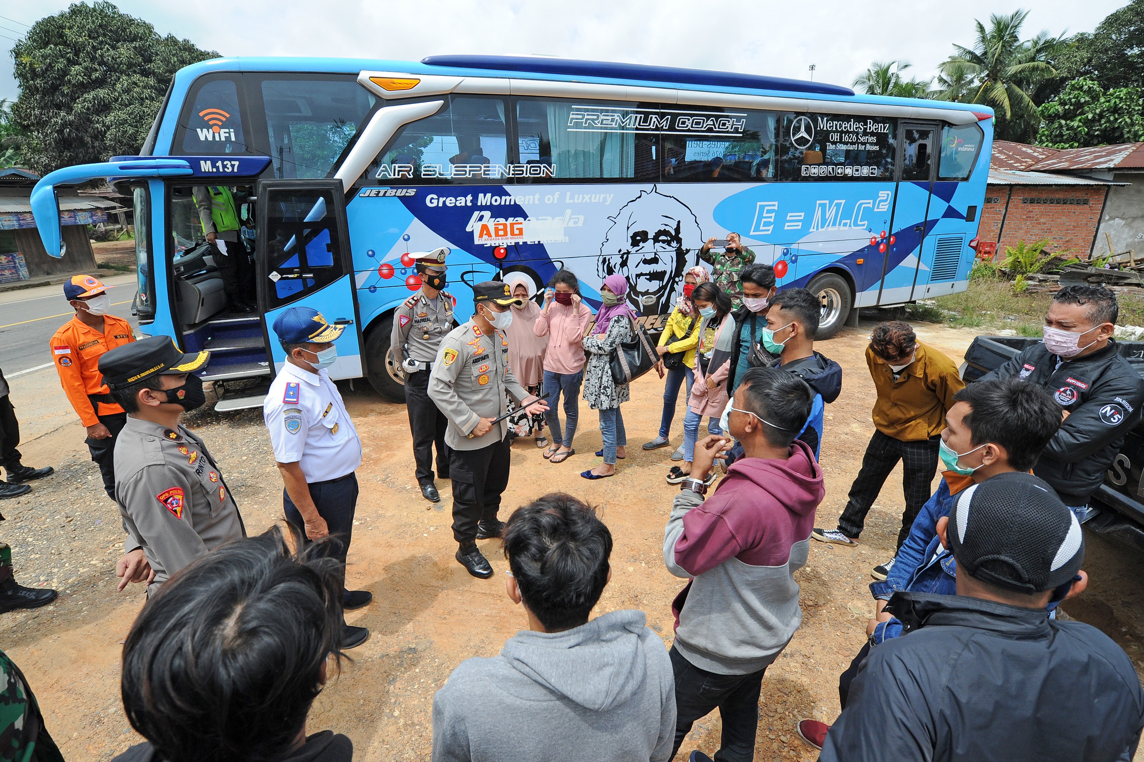 Petugas kepolisian dan instansi terkait menjelaskan persyaratan perjalanan kepada penumpang bus rute Jakarta-Padang yang diberhentikan.