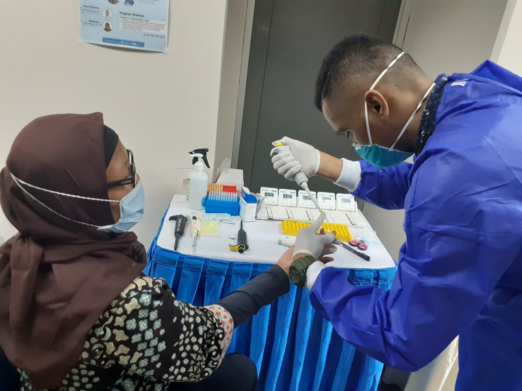 Petugas sedang mengambil darah untuk dilakukan pengecekan kadar antibodi setelah vaksinasi covi-19 kedua. 