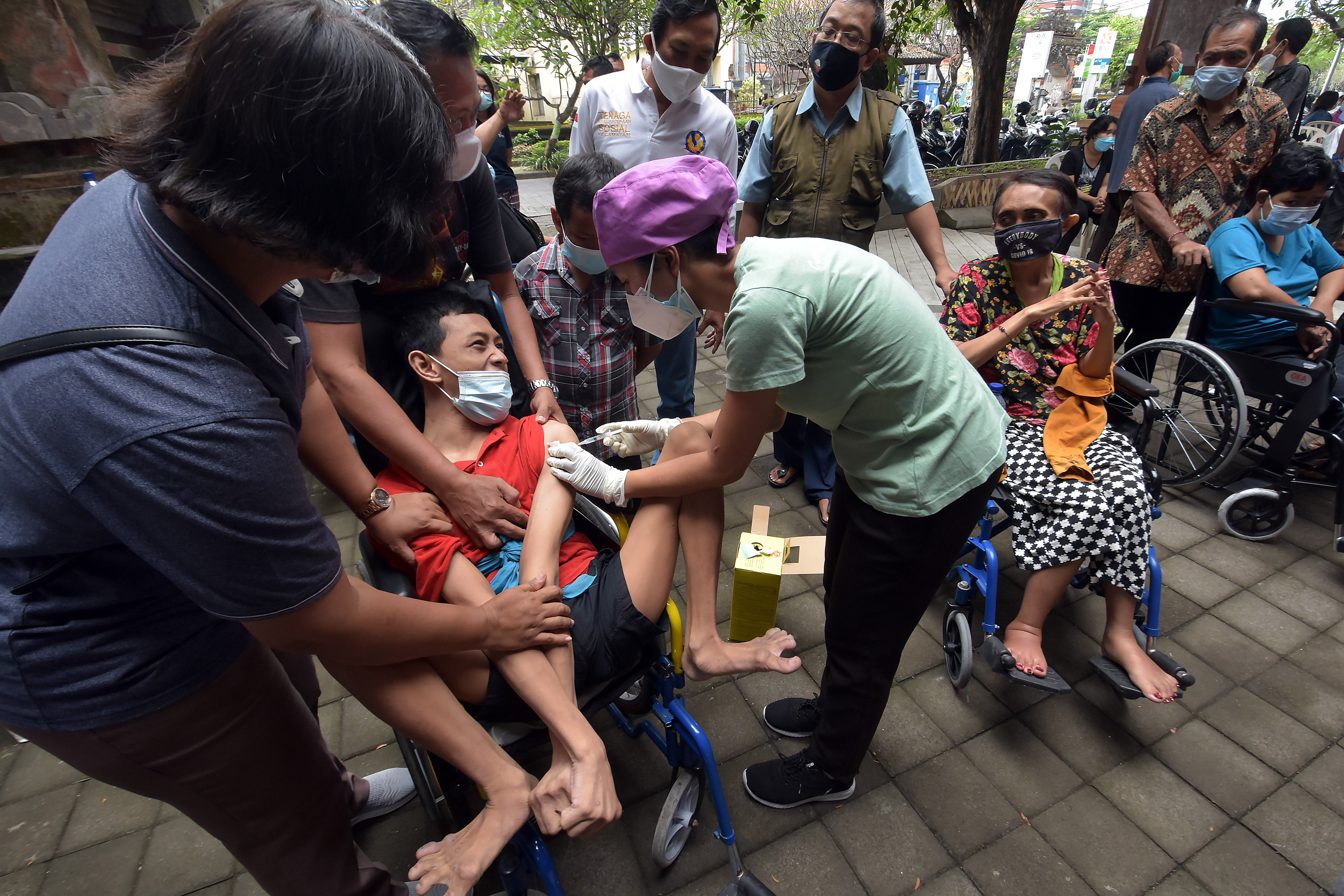 Petugas kesehatan menyuntikkan vaksin COVID-19 kepada penyandang tuna daksa di Rumah Bisabillitas, Denpasar, Bali, Minggu (9/5/2021). 