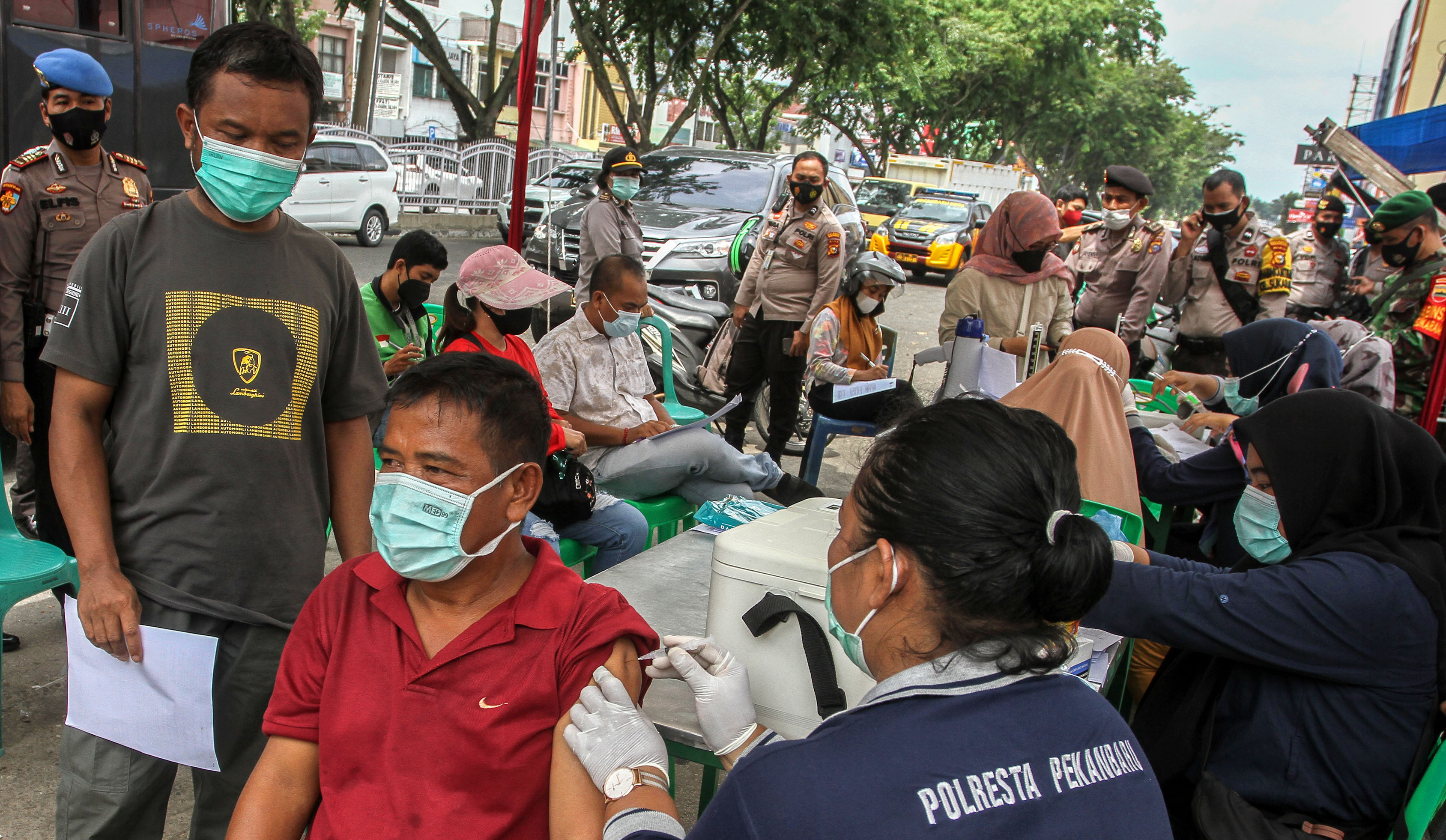  Petugas tim kesehatan Polresta Pekanbaru menyuntikkan vaksin COVID-19 kepada warga di Jalan Sudirman, Kota Pekanbaru, Riau, Rabu (26/5/2021