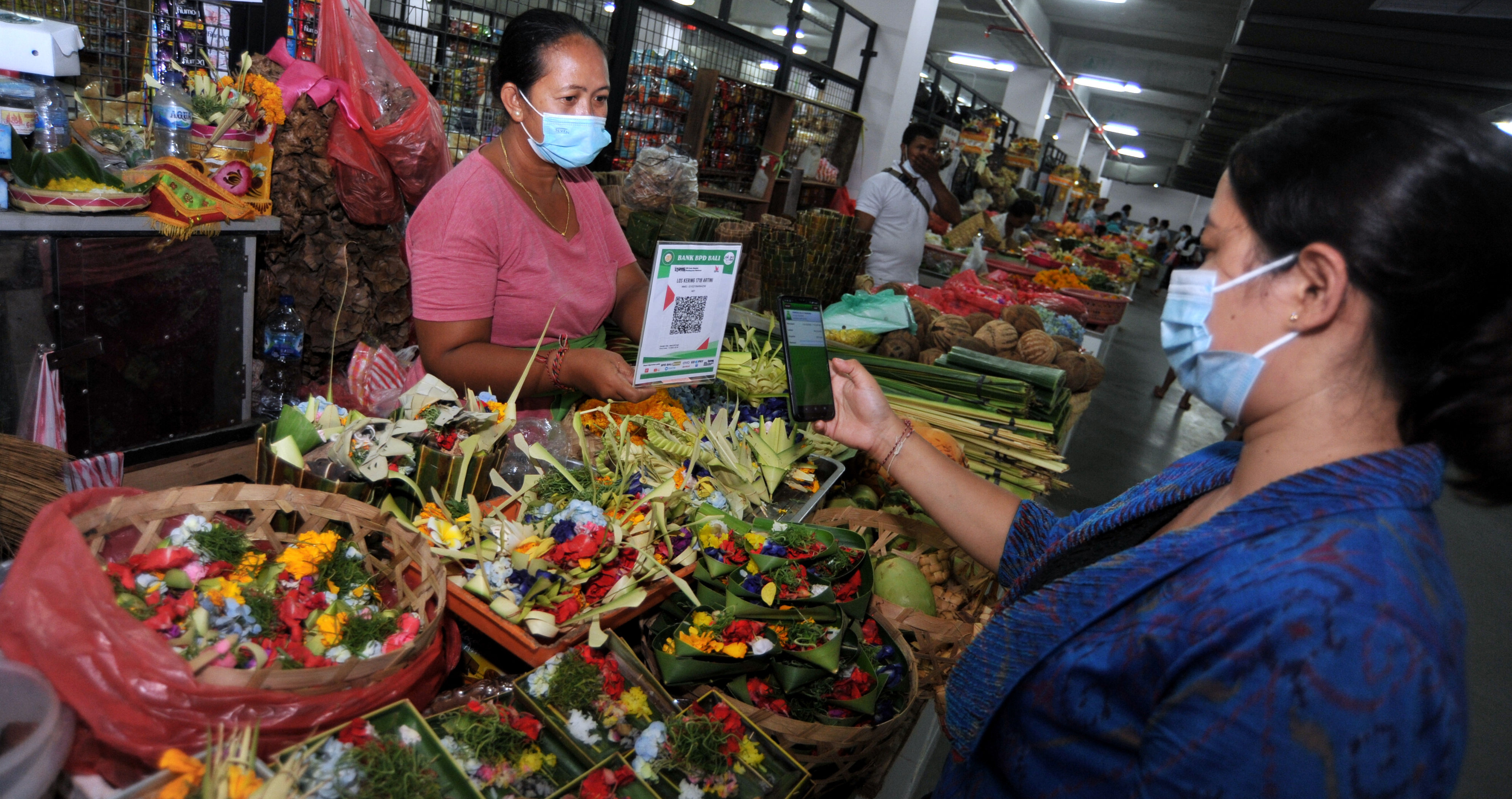 Warga melakukan transaksi pembayaran digital dengan menggunakan QRIS saat peresmian digitalisasi Pasar Banyuasri di Buleleng, Bali.