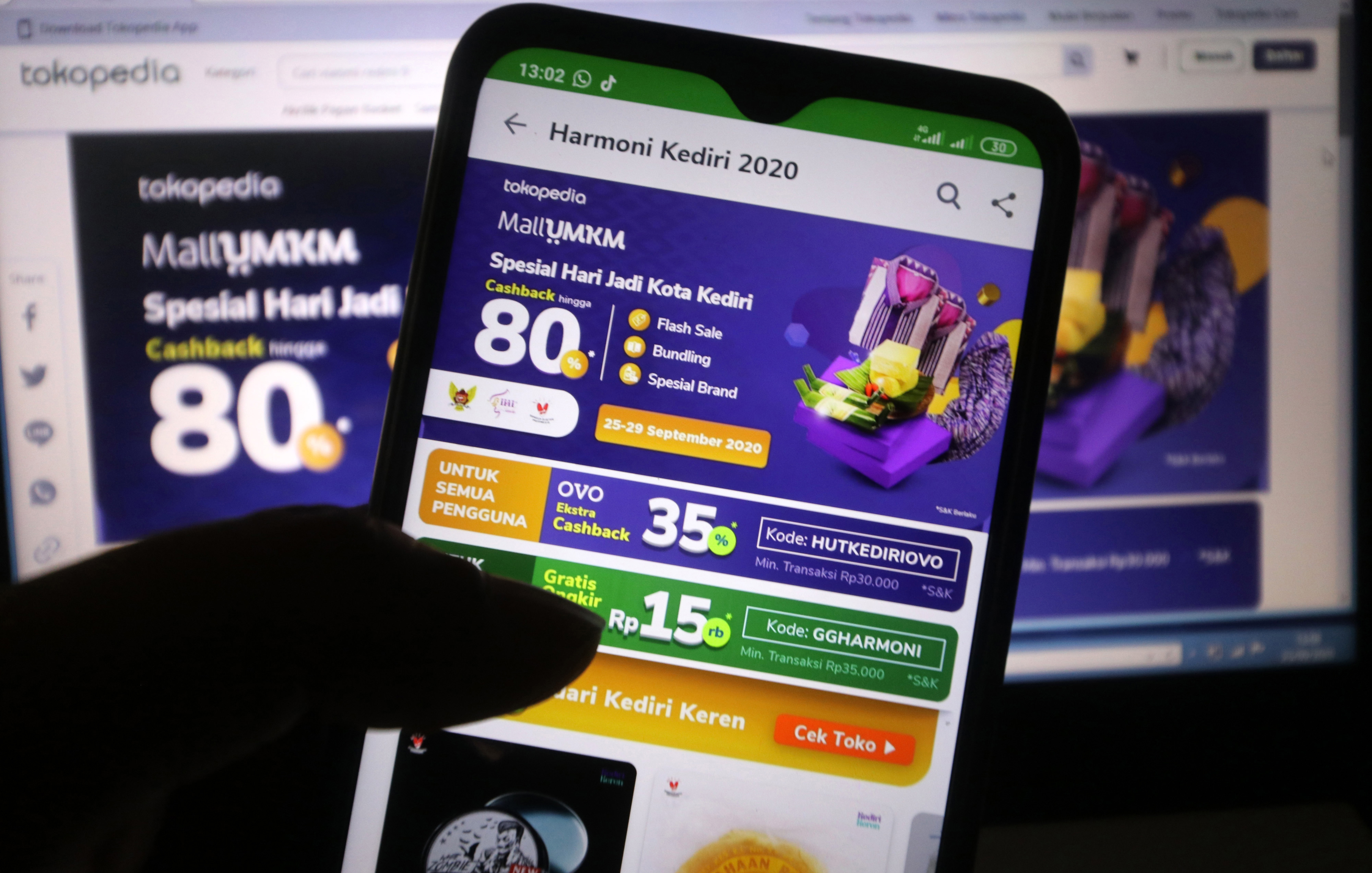 Warga membuka platform MallUMKM melalui telepon genggam untuk berbelanja.