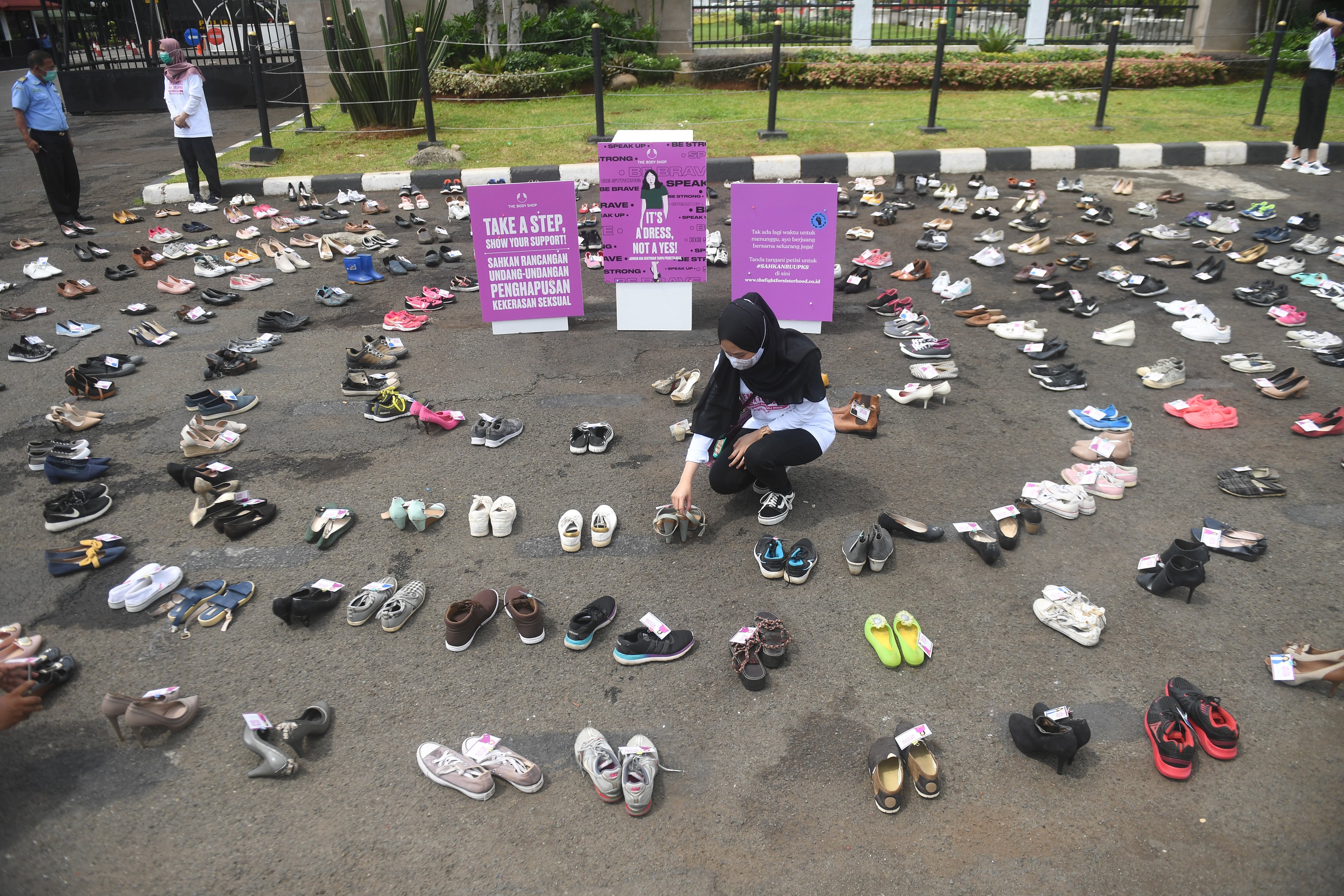 Pegiat perempuan merapikan sepatu saat aksi diam 500 Langkah Awal Sahkan RUU PKS di depan gedung DPR, Jakarta, Rabu (25/11/2020). 