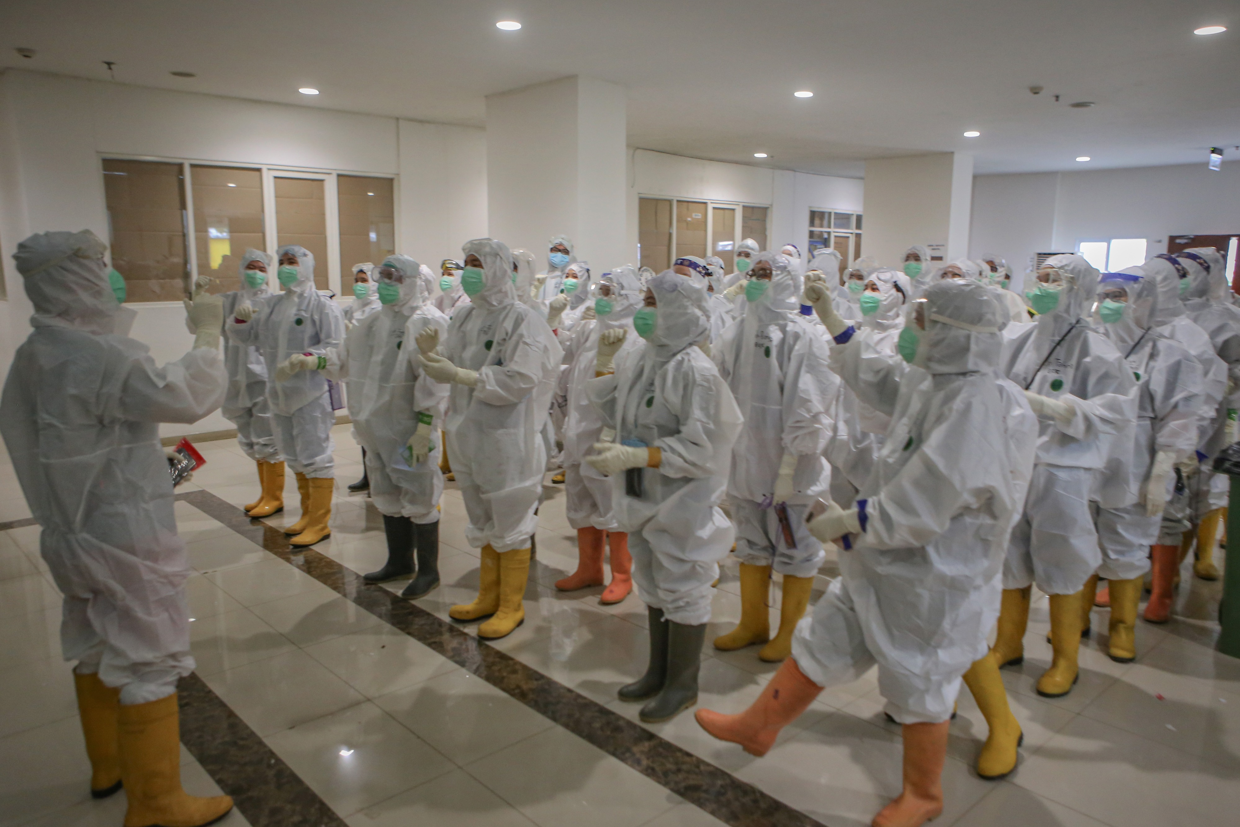 Sejumlah tenaga kesehatan bersiap sebelum melakukan perawatan terhadap pasien covid-19 di RSD Wisma Atlet, Jakarta.