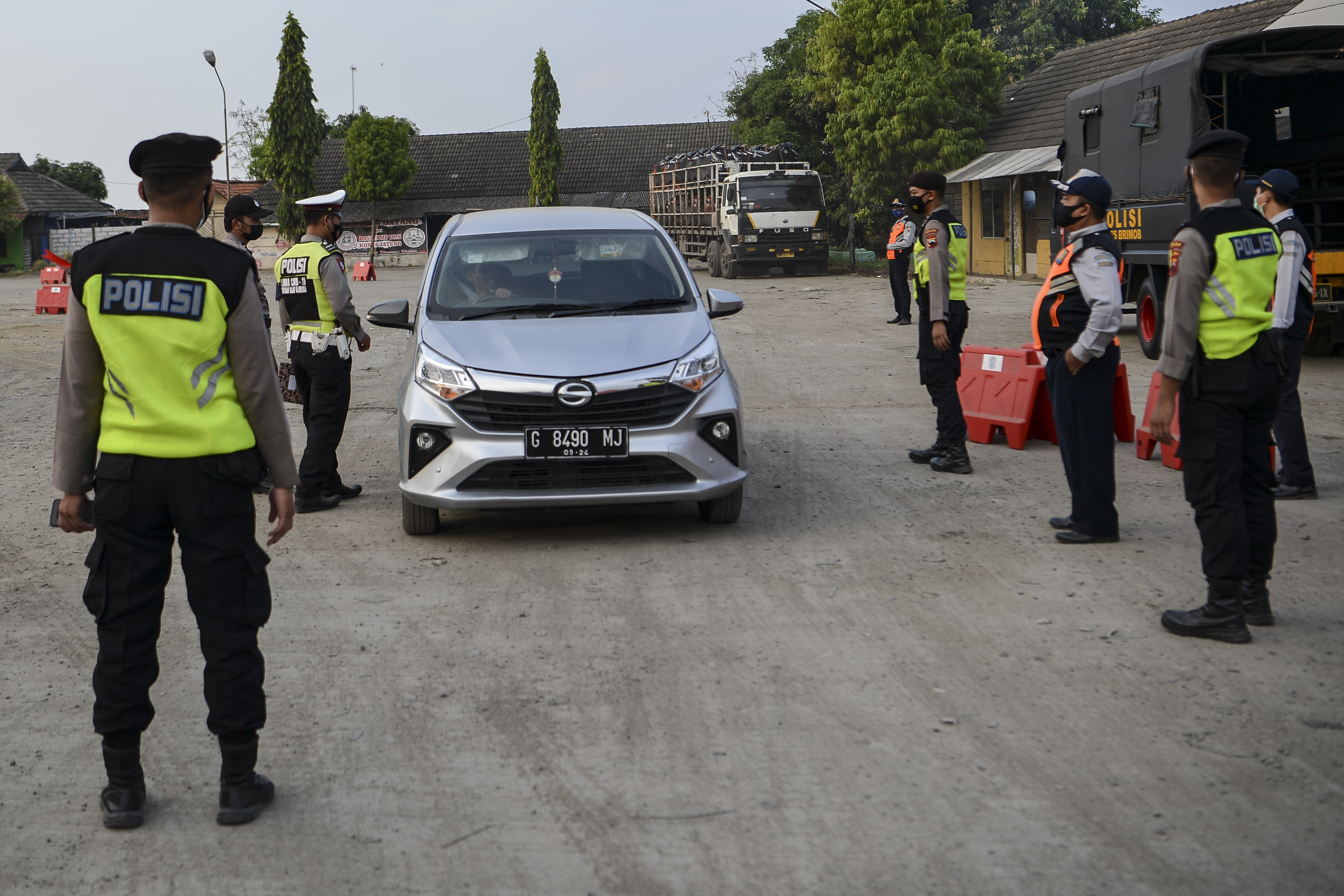 Petugas kepolisian memeriksa dokumen perjalanan pengemudi mobil di pos penyekatan mudik di Kecipir, Losari, Brebes, Jawa Tengah.