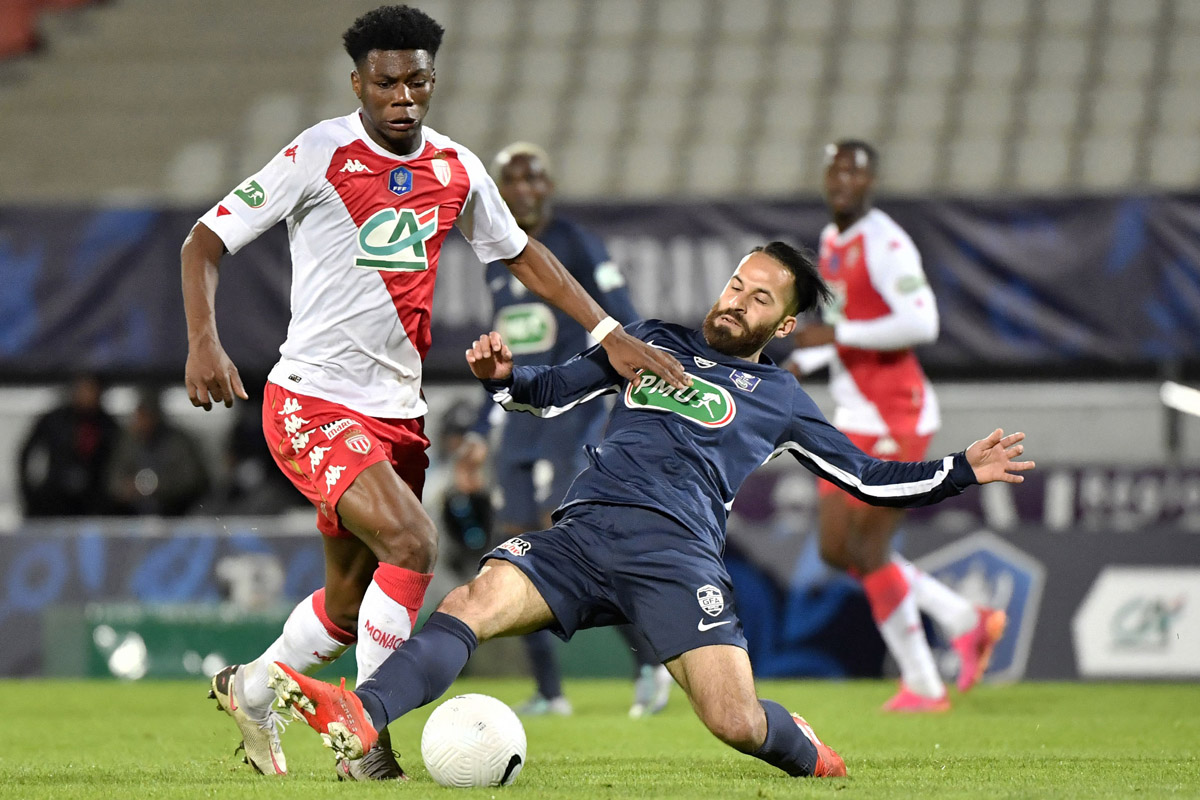 Pemaina AS Monaco Aurelien Tchouuameni (kiri) berusaha melewati hadangan pemain Rumilly dalam semifinal Piala Prancis, Jumat (14/5).