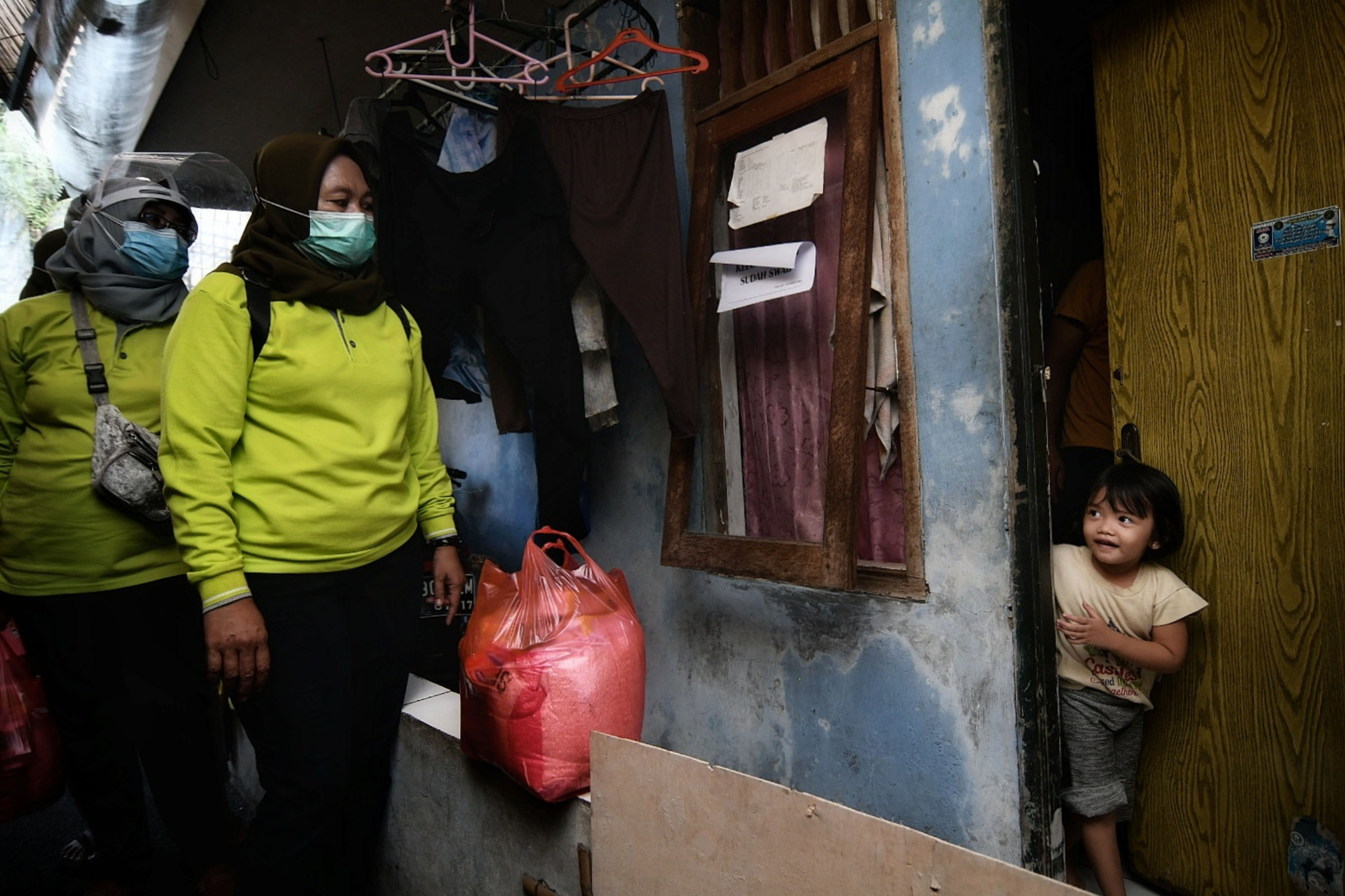 Petugas membagikan bantuan pangan kepada warga yang melakukan isolasi mandiri di Cilangkap, Jakarta.