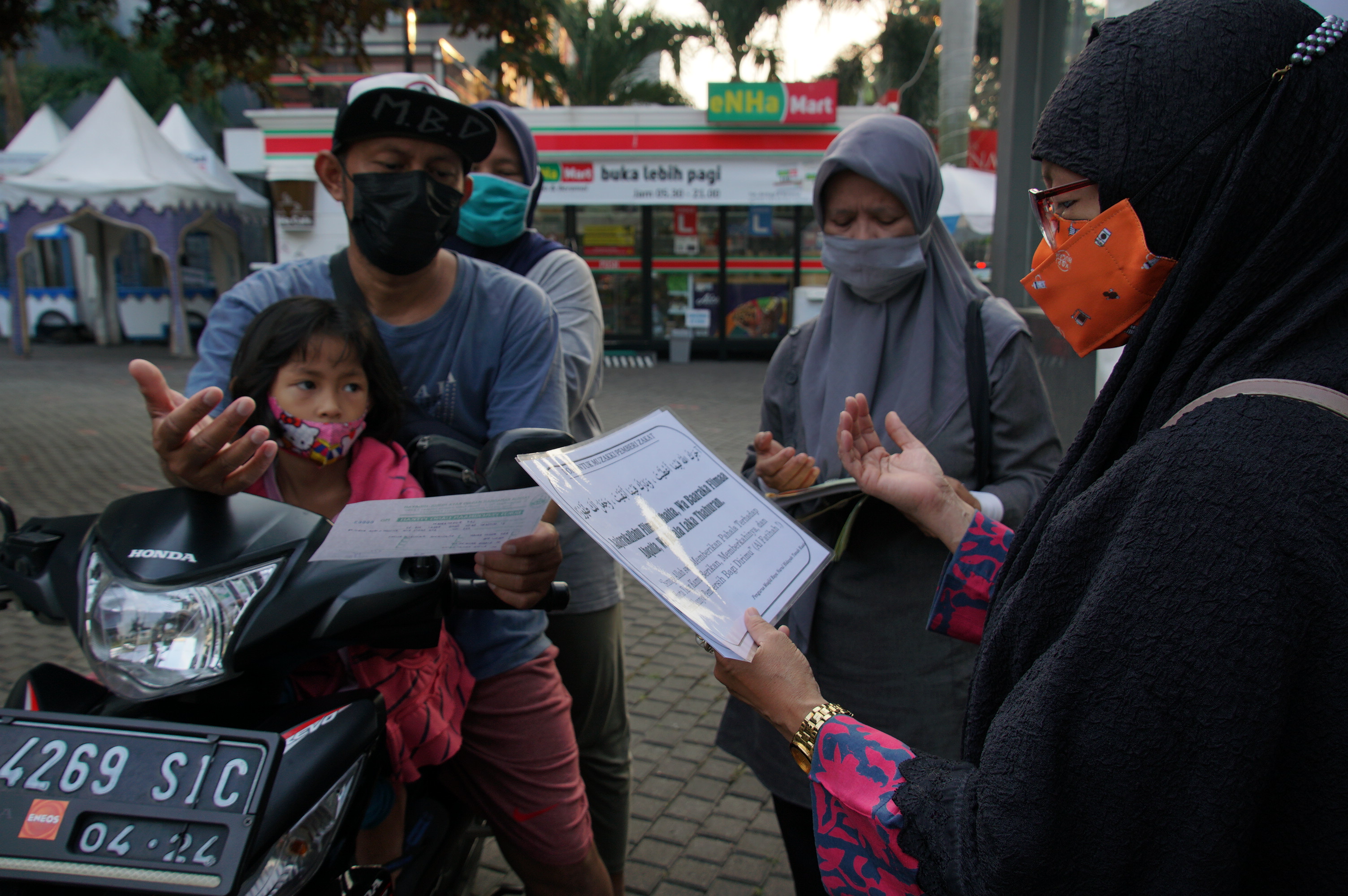 Pengendara motor membayar zakat secara Drive Thru di Masjid Nurul Hidayah, Tanah Kusir, Jakarta Selatan, Rabu (7/5/2021)