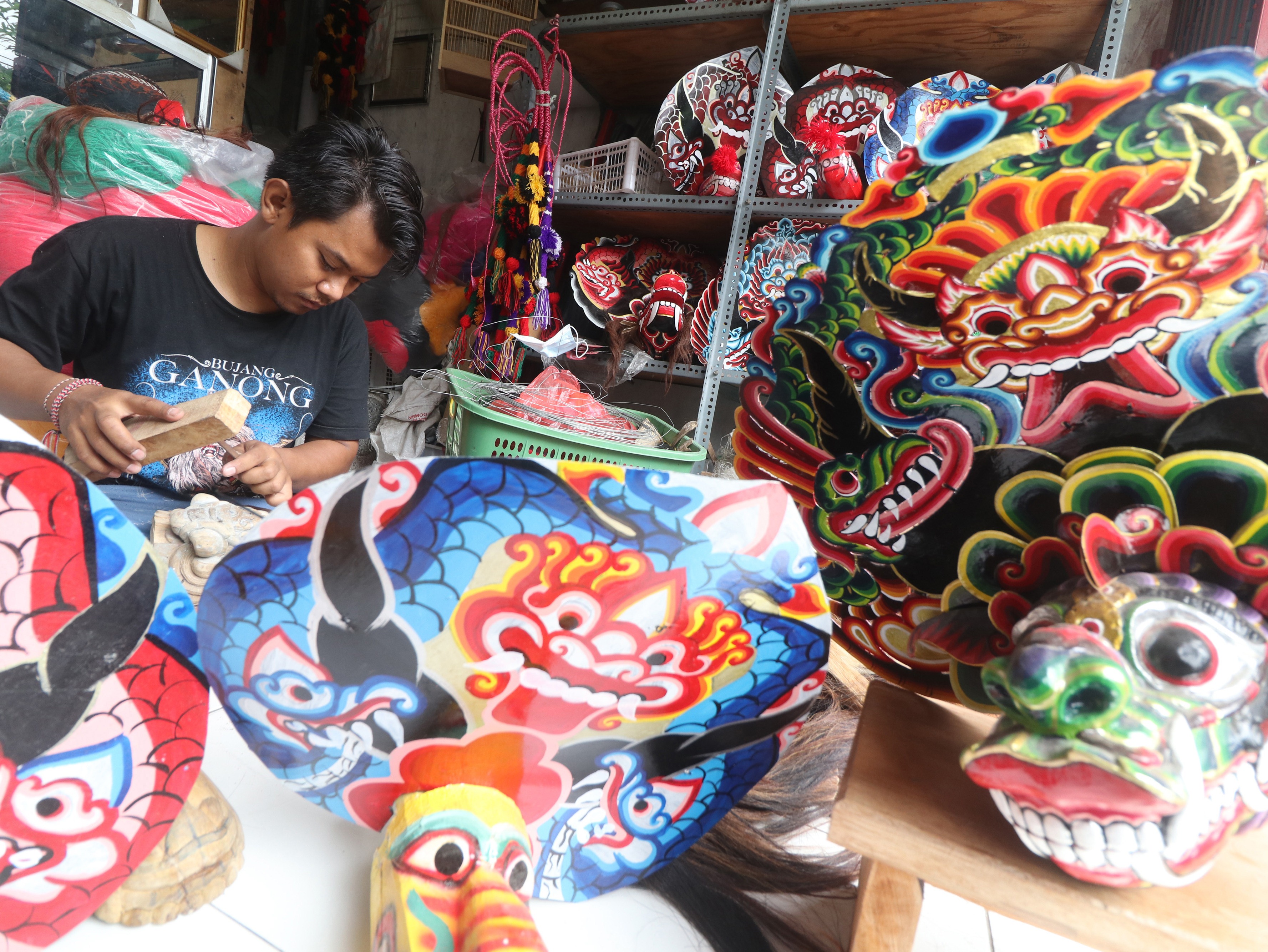 Perajin Mahmud Septian memproduksi barongan mainan anak di Desa Paron, Kediri, Jawa Timur.