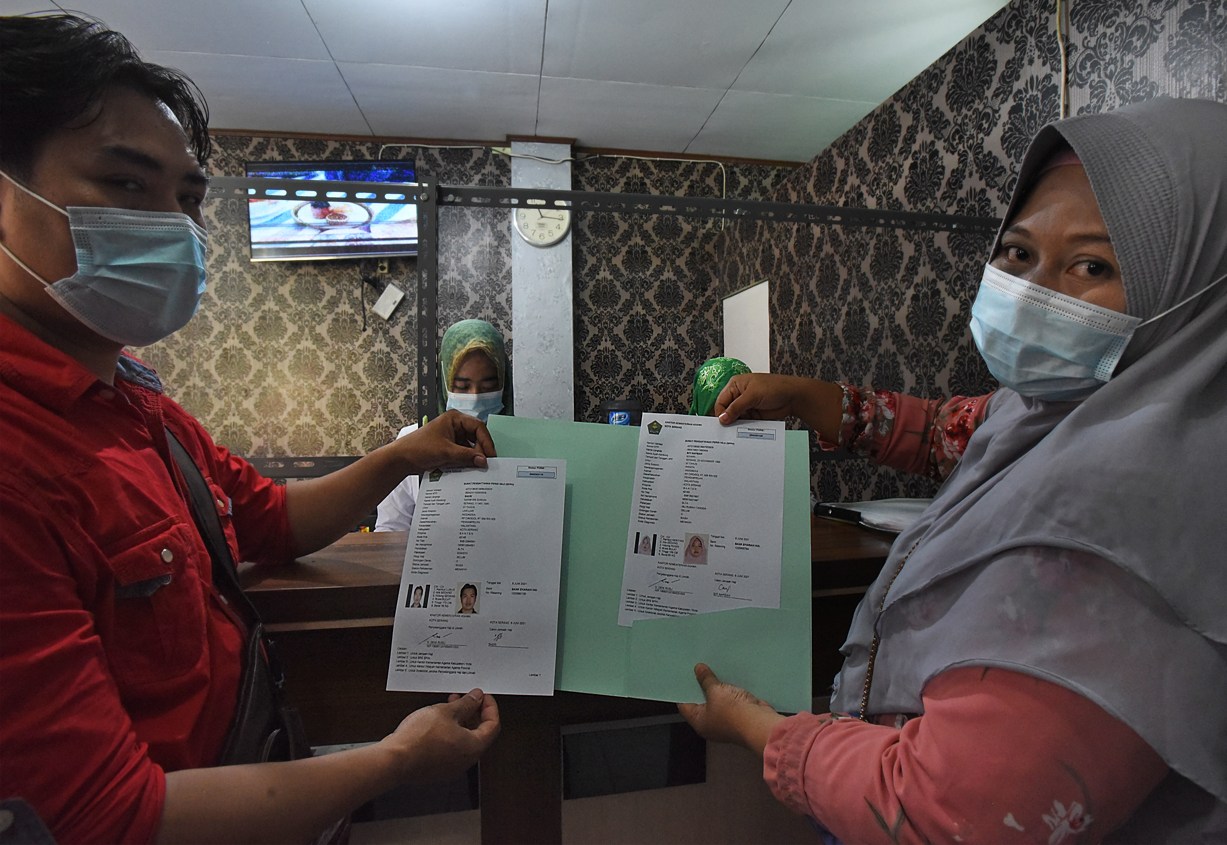 Pasangan suami isteri memperlihatkan Surat Pendaftaran Pergi Haji (SPPH) di Kantor Kemenag Kota Serang, Banten, Selasa (8/6/2021).
