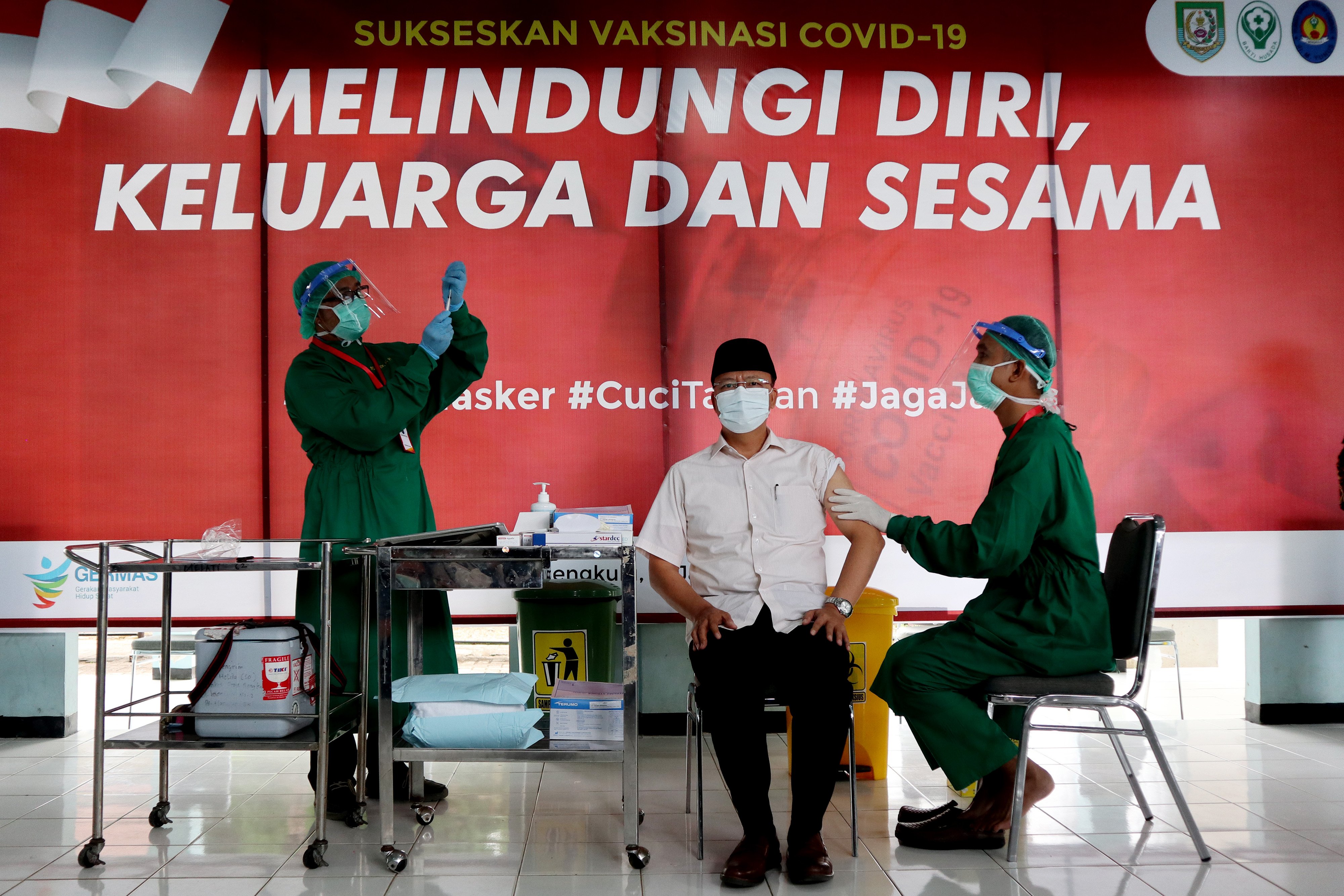 Gubernur Bengkulu Rohidin Mersyah (tengah) saat pelaksanaan vaksinasi perdana di RSUD M Yunus, Provinsi Bengkulu, Kamis (14/1/2021). 