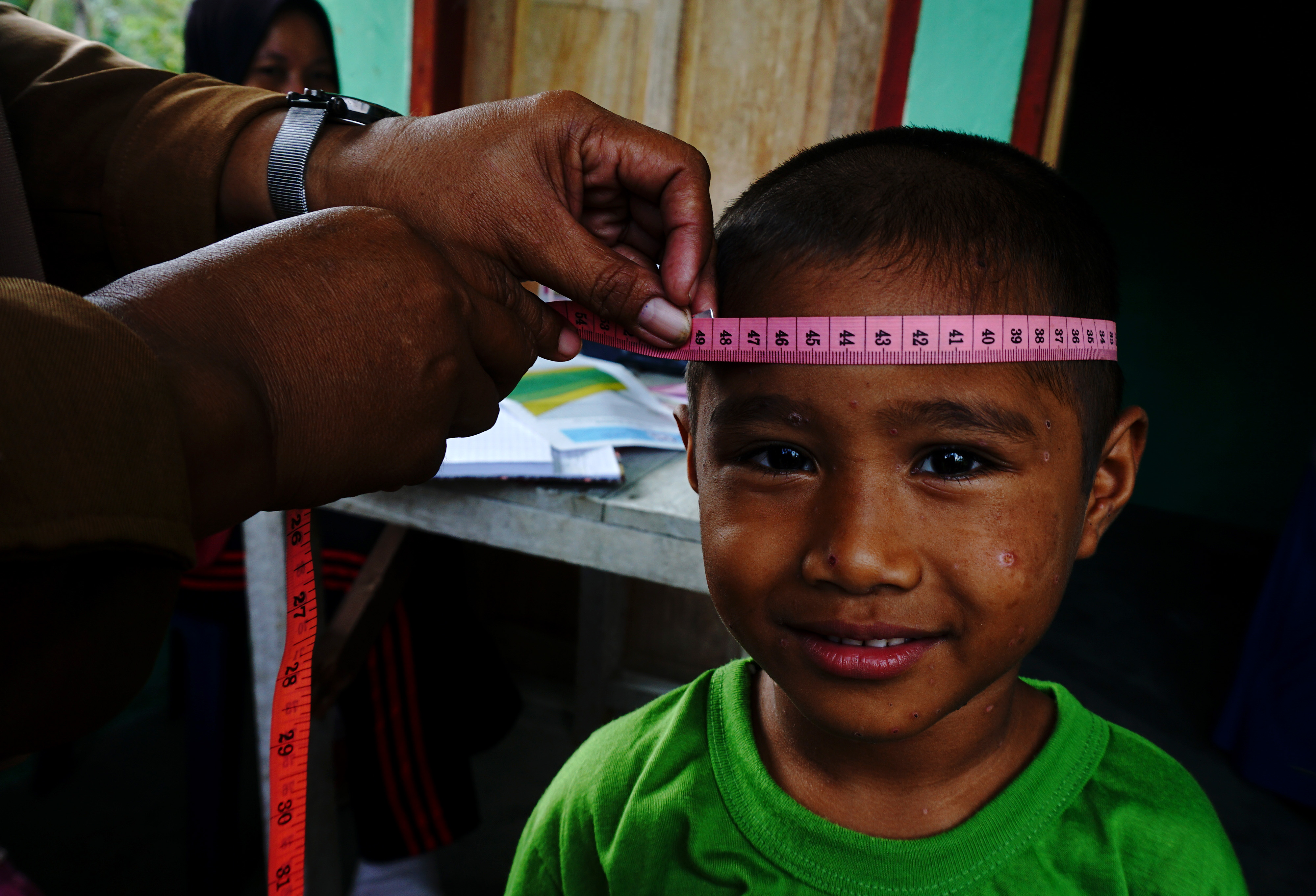 Petugas mengukur lingkar kepala seorang anak saat Posyandu di Desa Topore Kecamatan Papalang, Mamuju, Sulawesi Barat, Senin (12/4/2021)