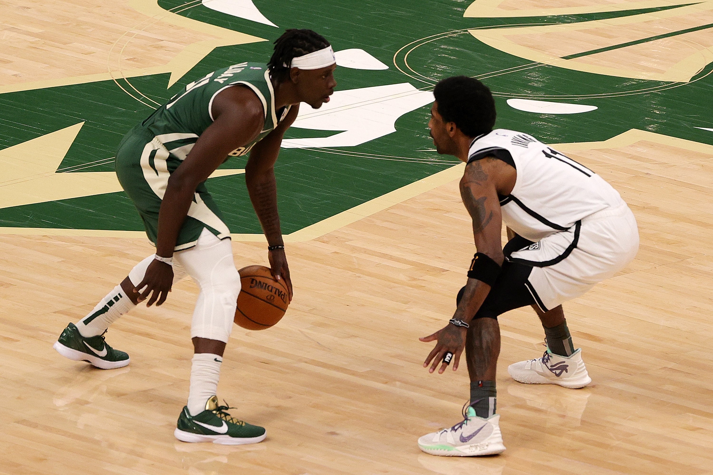 Pemain Milwaukee Bucks Jrue Holiday (kanan) berhadapan dengan pemain Brooklyn Nets Kyrie Irving di Gim 3 playoff NBA.