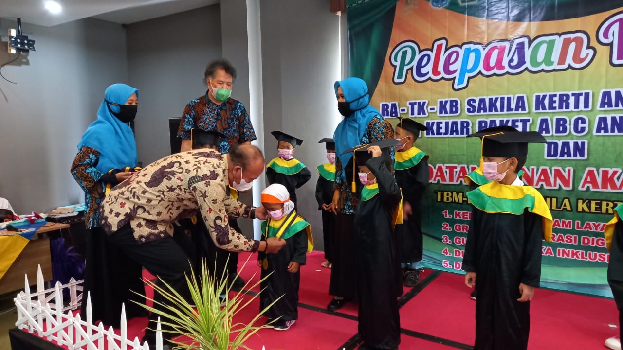 Sekretaris Daerah/Sekda Kota Tegal Jawa Tengah, Johardi mengalungkan tanda wisuda kepada seorang siswi.