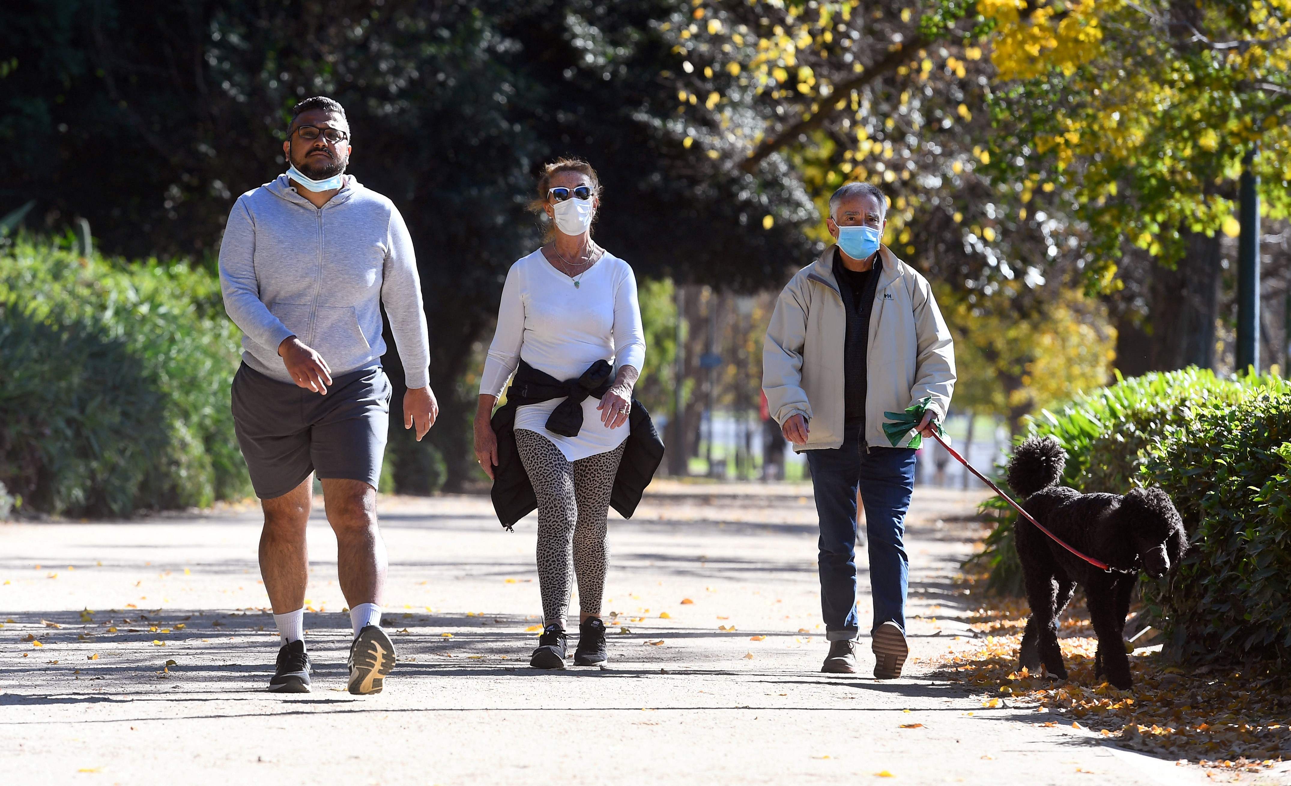 Warga berolahraga dengan mengenakan masker di Melbourne, Australia.