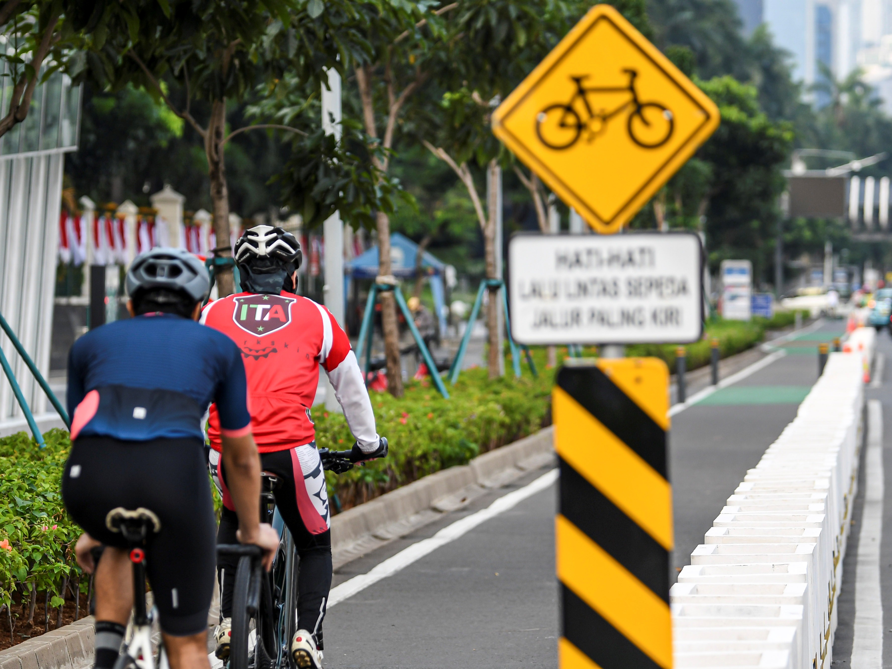 Pesepeda memacu kecepatannya di jalur sepeda permanen di Jalan Jenderal Sudirman, Jakarta.