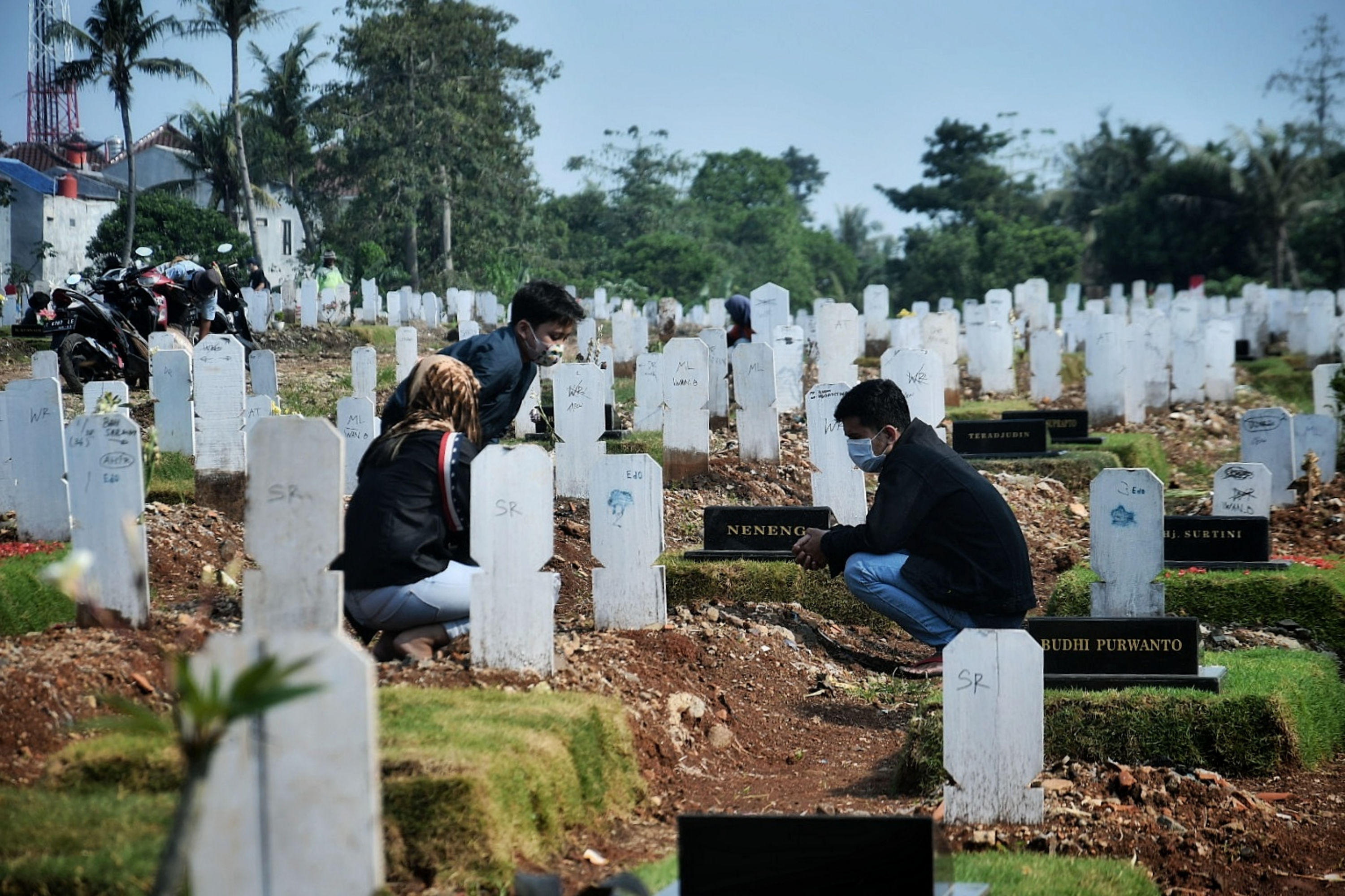 Warga berziarah makam di TPU khusus covid-19 Srengseng Sawah, Jakarta.
