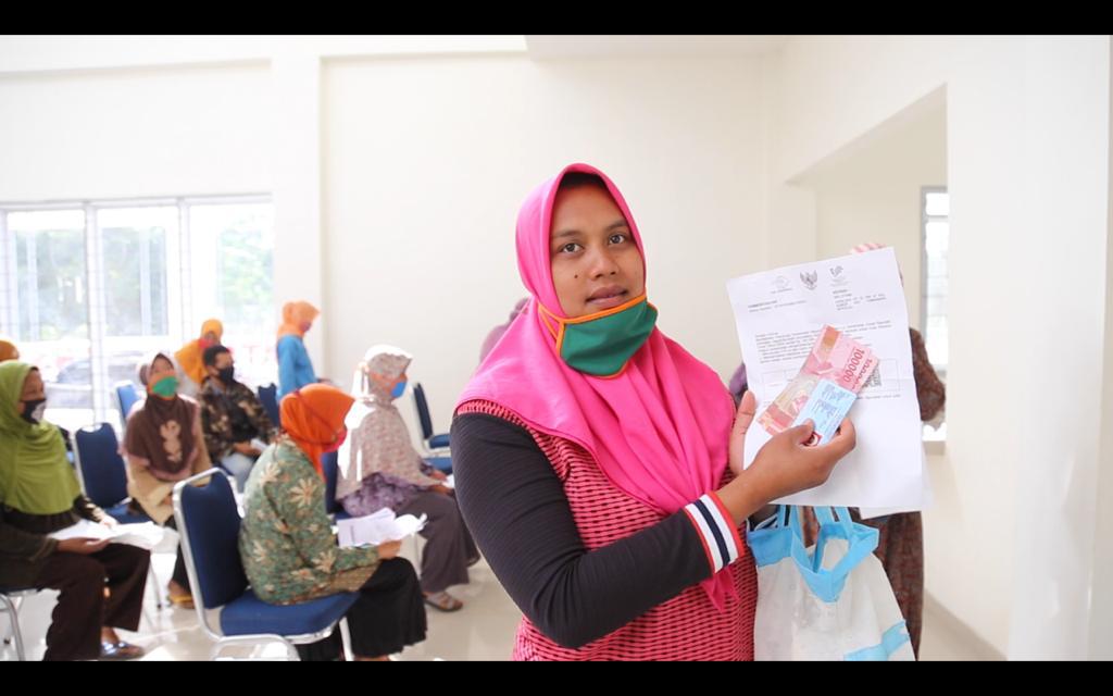 Warga Keluarga Penerima Manfaat (KPM) menunjukkan uang program sembako yang diterimanya.   