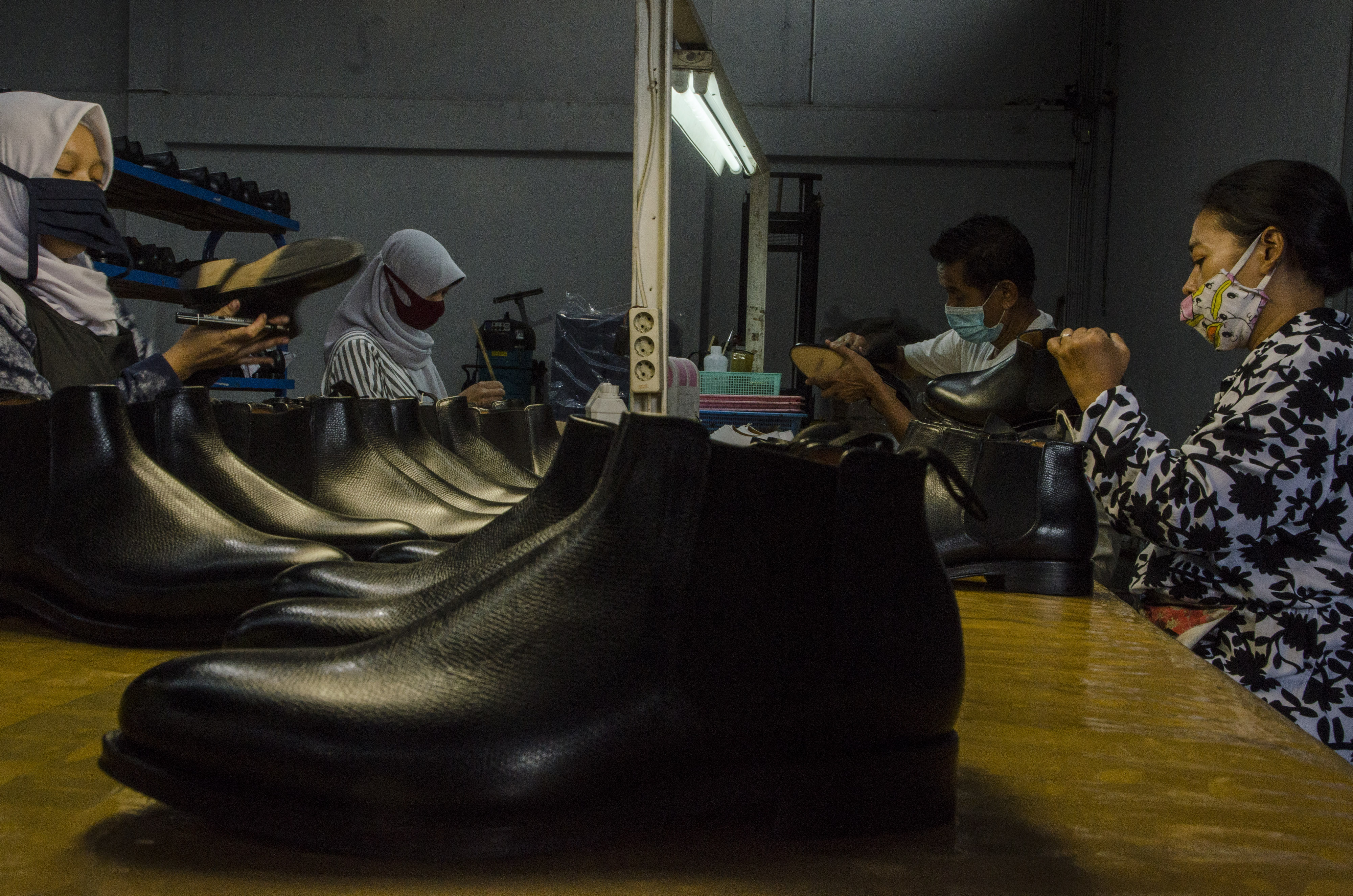 Pekerja menyelesaikan pembuatan sepatu kulit di pabrik wilayah Jawa Barat.